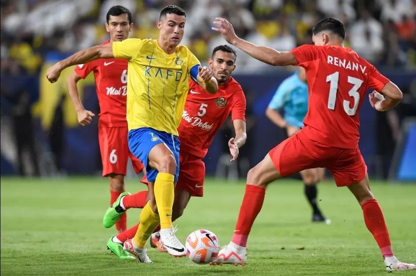 Bintang Al Nassr FC Cristiano Ronaldo melewati bek Shabab Al Ahli Renan dalam playoff Liga Champions Asia di King Saud University Stadium, Riyadh, kemarin (23/8) (YAZID AL DUWIHI/AFP)