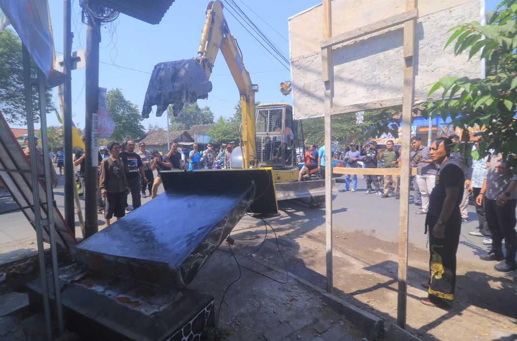 DIBONGKAR: Salah satu perguruan pencak silat di Kabupaten Madiun membongkar tugunya yang berada di fasum Kelurahan Bangunsari, Mejayan, kemarin (25/8). (R. BAGUS RAHADI/RADAR CARUBAN)