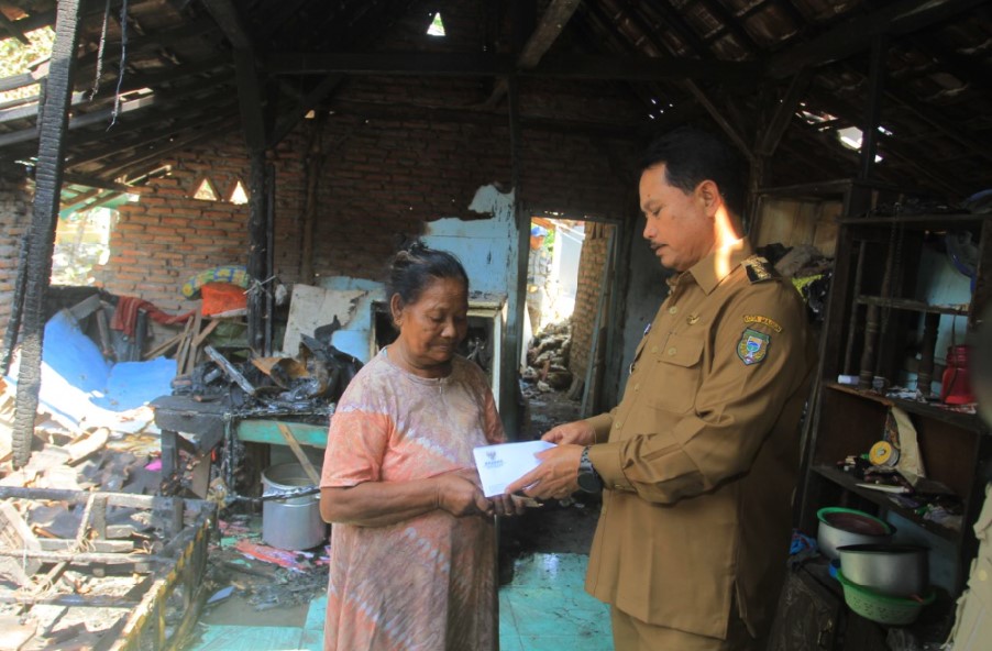 CEPAT TANGGAP: Maidi menyalurkan bantuan pemberian dinsos-PPPA dan Baznas kepada Rumi yang rumahnya hangus terbakar kemarin (28/8). (BAGAS BIMANTARA/RADAR MADIUN)