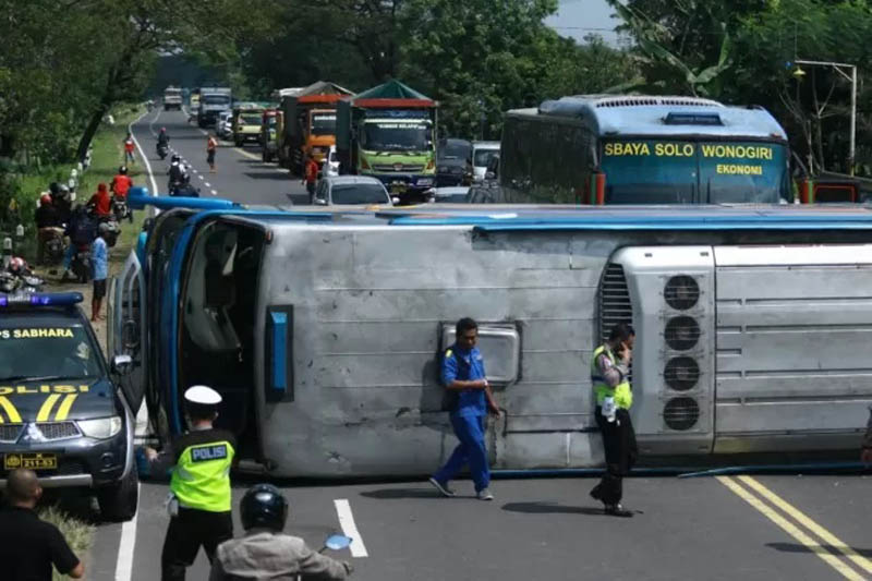 LAKA TUNGGAL: Bus SR W 7216 UZ terguling di di Balerejo, Selasa (31/5) lalu. Kemarin polisi menetapkan sopir bus itu sebagai tersangka. (R. BAGUS RAHADI/JAWA POS RADAR MADIUN)