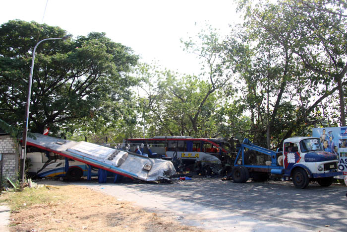 RUSAK PARAH : Polisi sempat menutup total arus lalu lintas di Jalan Raya Magetan-Ngawi untuk proses evakuasi bangkai bus Ekda dan Sugeng Rahayu. (ASEP SAEFUL BACHRI/JAWA POS RADAR NGAWI)