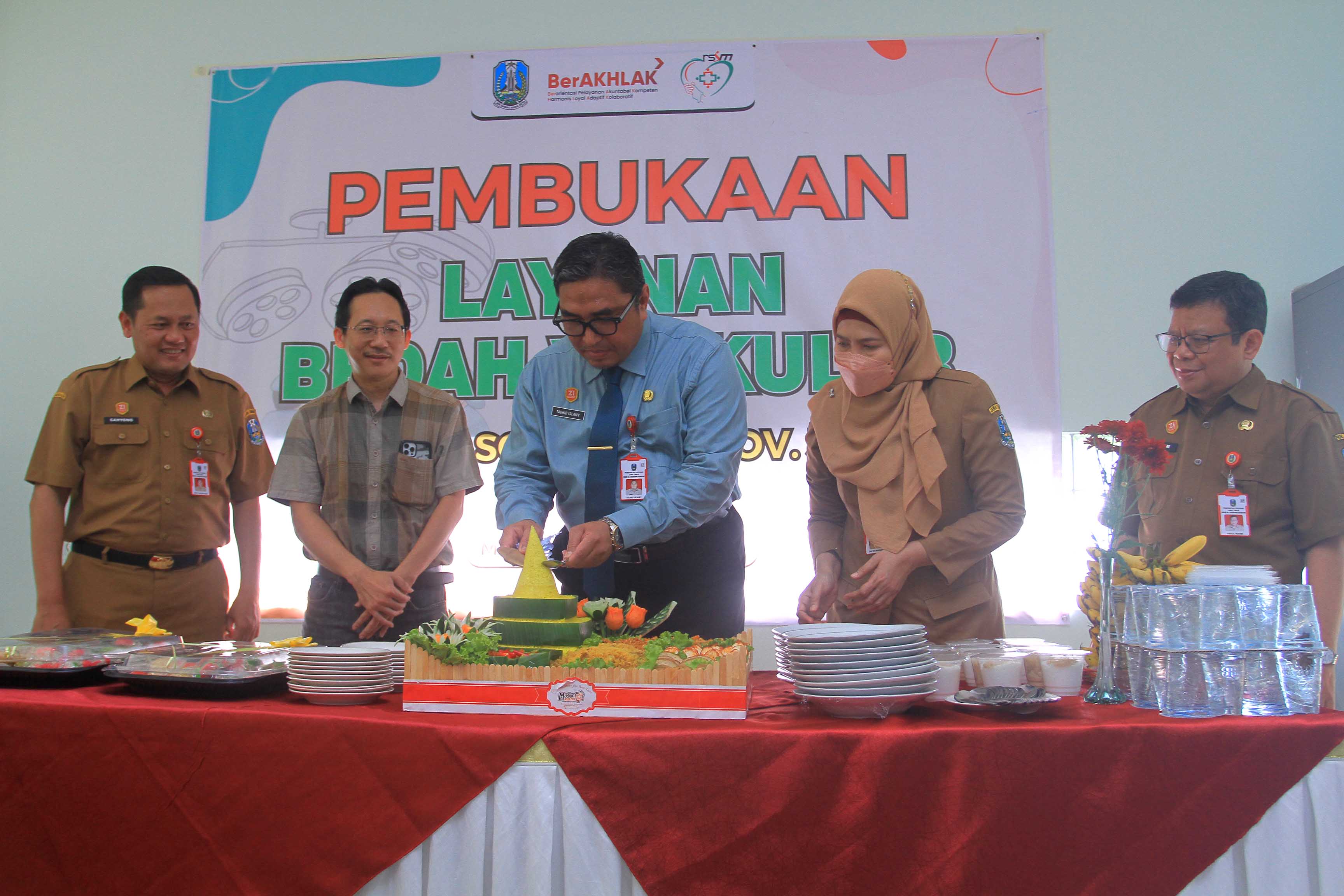 MERIAH: Kepala Smala Wahyu Astuti Budi bersama Kacabdindik Wilayah Madiun-Ngawi Lena saat prosesi pemotongan tumpeng. (ARCHI FIRDAUS/RADAR MADIUN)