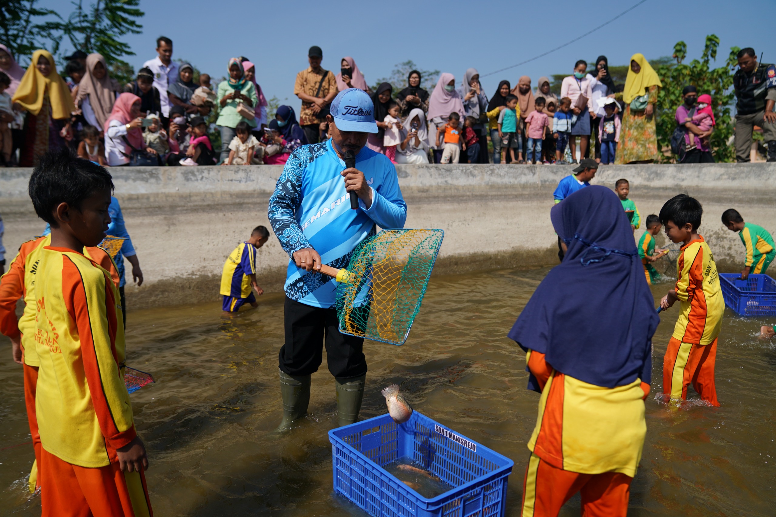 BASAH: Wali Kota Madiun Maidi bersama anak-anak menangkap ikan di kolam milik DKPP setempat kemarin (6/9).&nbsp;(DISKOMINFO UNTUK RADAR MADIUN)