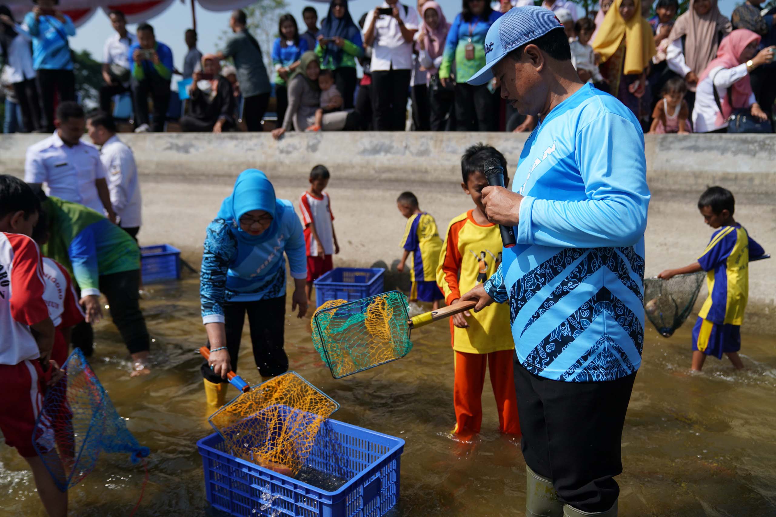 GEMARIKAN: Wali Kota Maidi mengedukasi siswa SD di Kota Madiun untuk makan ikan melalui kegiatan menangkap dan memasak ikan beberapa waktu lalu. (DISKOMINFO UNTUK JAWA POS RADAR MADIUN)