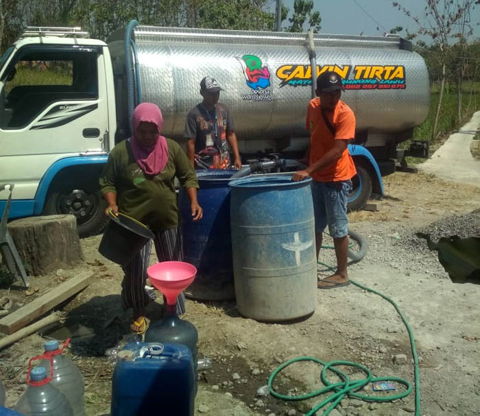 BERI BANTUAN: Warga berbondong-bondong mengambil bantuan air bersih, beberapa hari lalu. (ASEP SYAEFUL BACHRI/JAWA POS RADAR NGAWI)