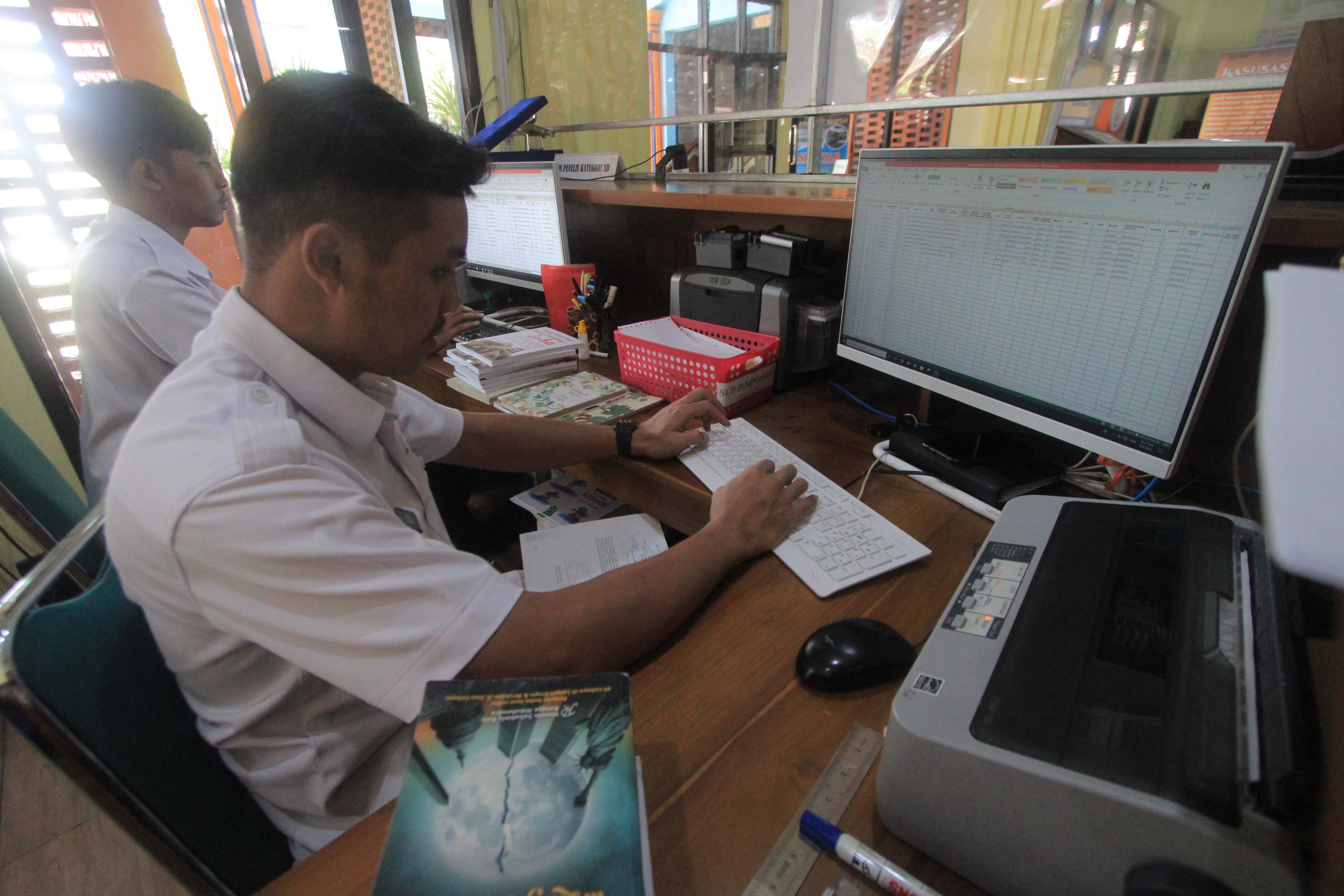 LABELISASI: Petugas Dinas Arpus Magetan sibuk menyiapkan tahapan penyaluran dua ribu eksemplar buku ke GPLM.&nbsp;(AJI PUTRA/JAWA POS RADAR MAGETAN)