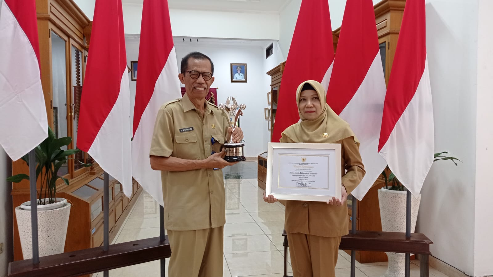 PRESTASI: Bupati Magetan Suprawoto didampingi Kepala DPPKBPPPA Magetan Furiana Kartini saat menunjukan penghargaan KLA 2023 di Ruang Jamuan Pendopo Surya Graha kemarin. (ERIC WIBOWO/RADAR MAGETAN)