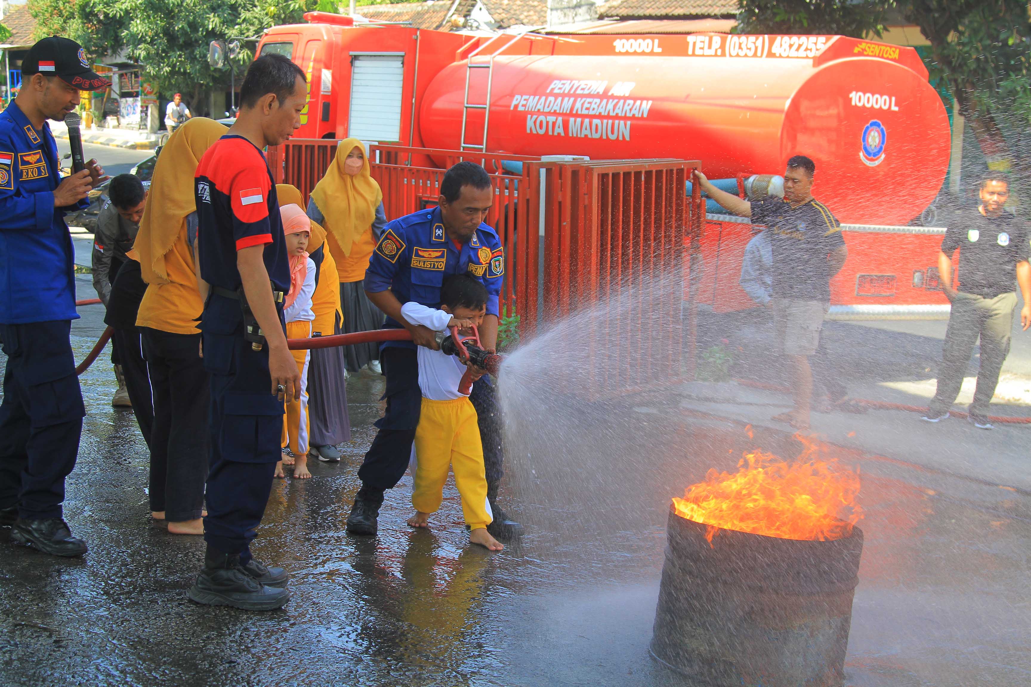 PADAMKAN KEBAKARAN: Anak-anak PAUD dikenalkan dengan pekerjaan pemadam kebakaran, kemarin (15/9).&nbsp;(BAGAS BIMANTARA/RADAR MADIUN)