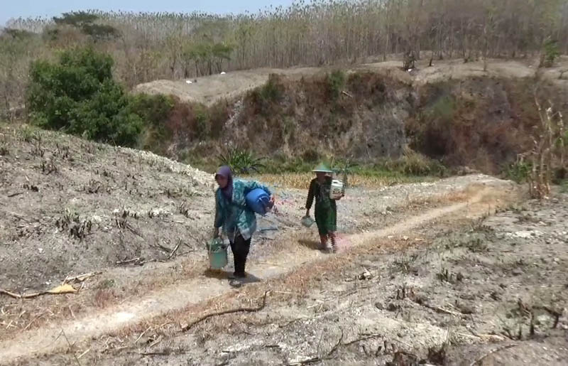 KEKERINGAN: Sejumlah warga Dusun Glagah Selang, Papungan, Pitu mengambil air dari sungai untuk keperluan mandi dan mencuci. (ASEP SYAEFUL BACHRI/JAWA POS RADAR NGAWI)