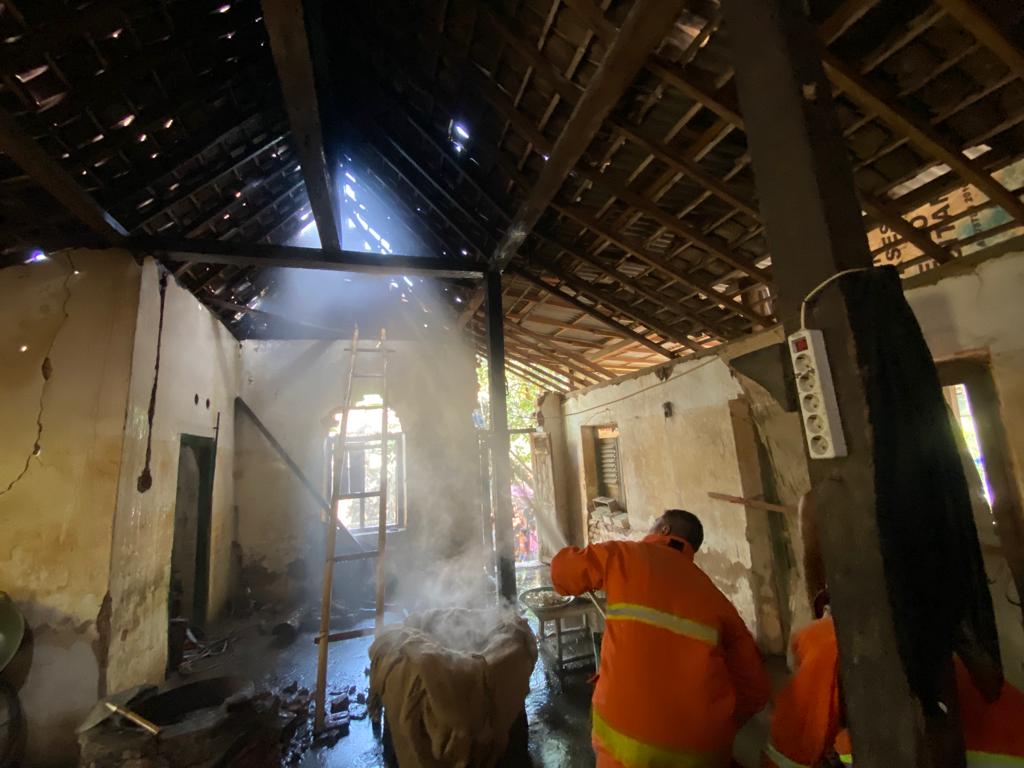 DIPADAMKAN WARGA: Petugas Damkar Pacitan melakukan pembasahan pabrik tahu tuna di Dusun Suruhan, Sirnoboyo, setelah terbakar, Minggu (17/9) pagi kemarin. (NUR CAHYONO/RADAR PACITAN)