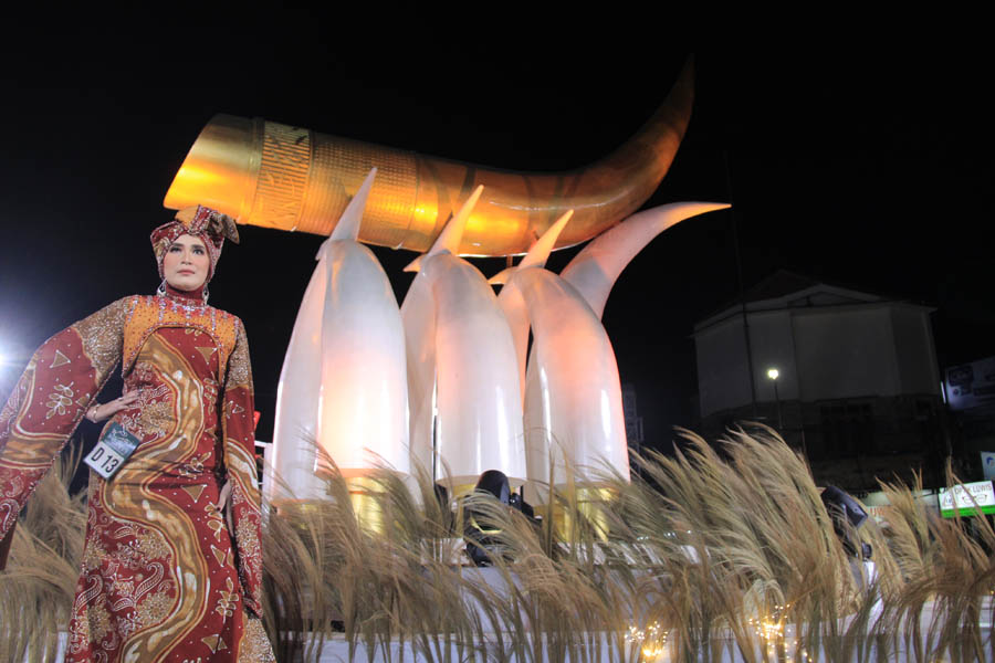 IKON NGAWI : Salah satu model Ngawi Batik Fashion 2023 memamerkan busana yang dikenakannya di Tugu Kartonyono, Sabtu (16/9). (AJI PUTRA/JAWA POS RADAR MADIUN)