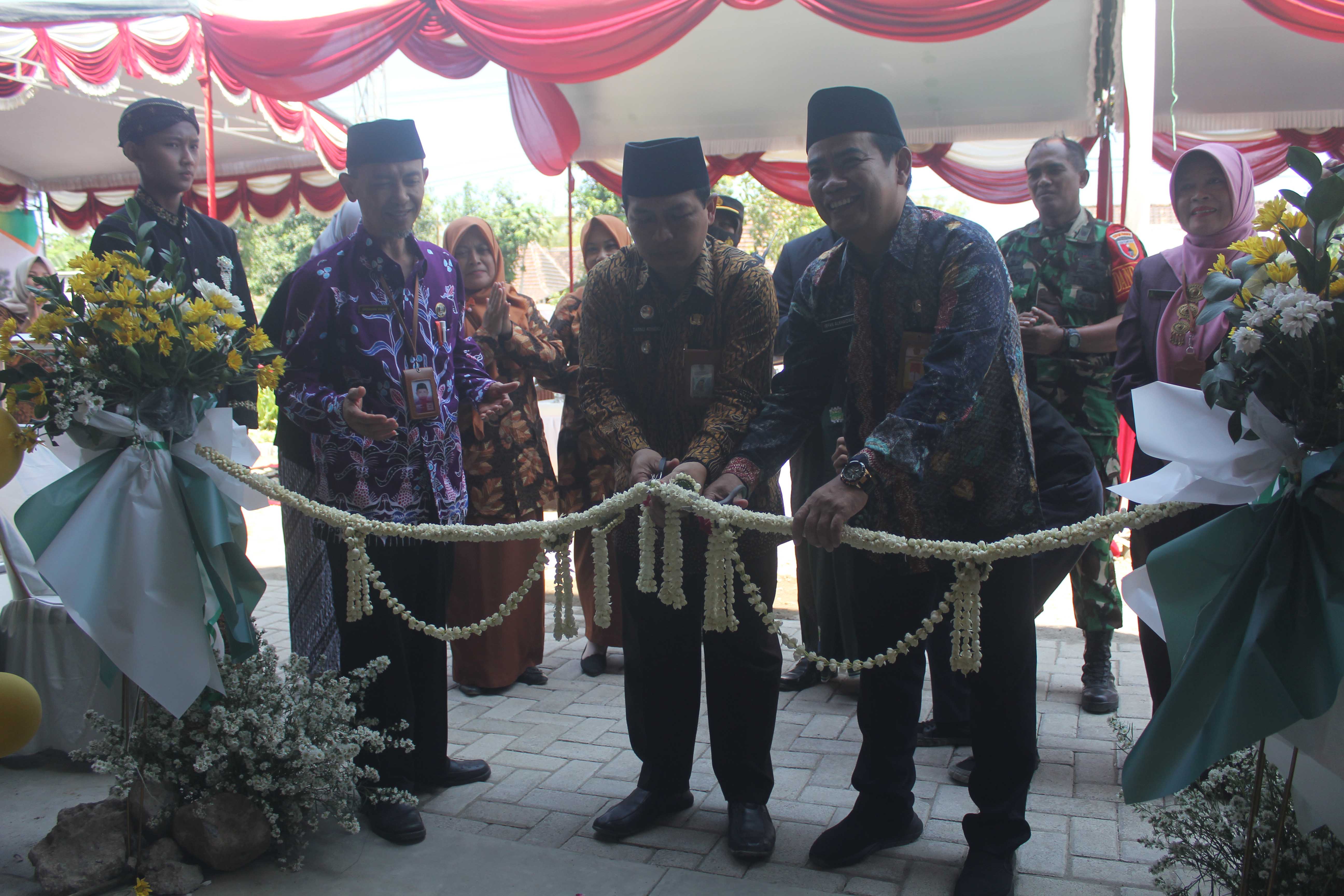 SIMBOLIS: Kepala Kemenag, camat Kebonsari, bersama Kepala MTsN 2 Kabupaten Madiun Ummu Nadifah memotong pita dalam tasyakuran selesainya pembangunan enam RKB.&nbsp;(ARCHI FIRDAUS/RADAR CARUBAN)