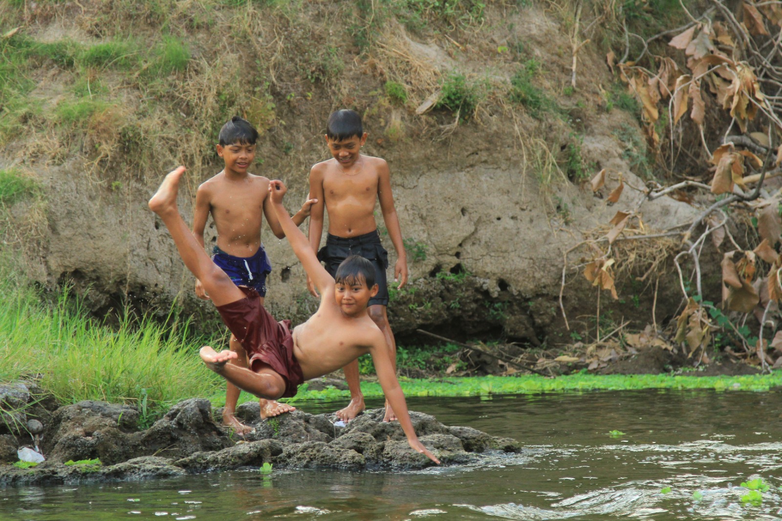 ADUS KALI: Sejumlah anak-anak bermain di Kali Madiun. (BAGAS BIMANTARA/RADAR MADIUN)