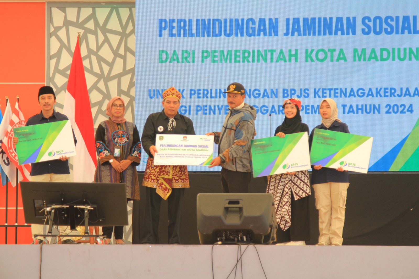 SIMBOLIS: Wali Kota Maidi menyerahkan kartu BPJS Ketenagakerjaan kepada PPS, sekretaris PPS, dan PPK didampingi Kepala BPJS Ketenagakerjaan Cabang Madiun Zakiah dan Ketua KPU Wisnu Wardhana.