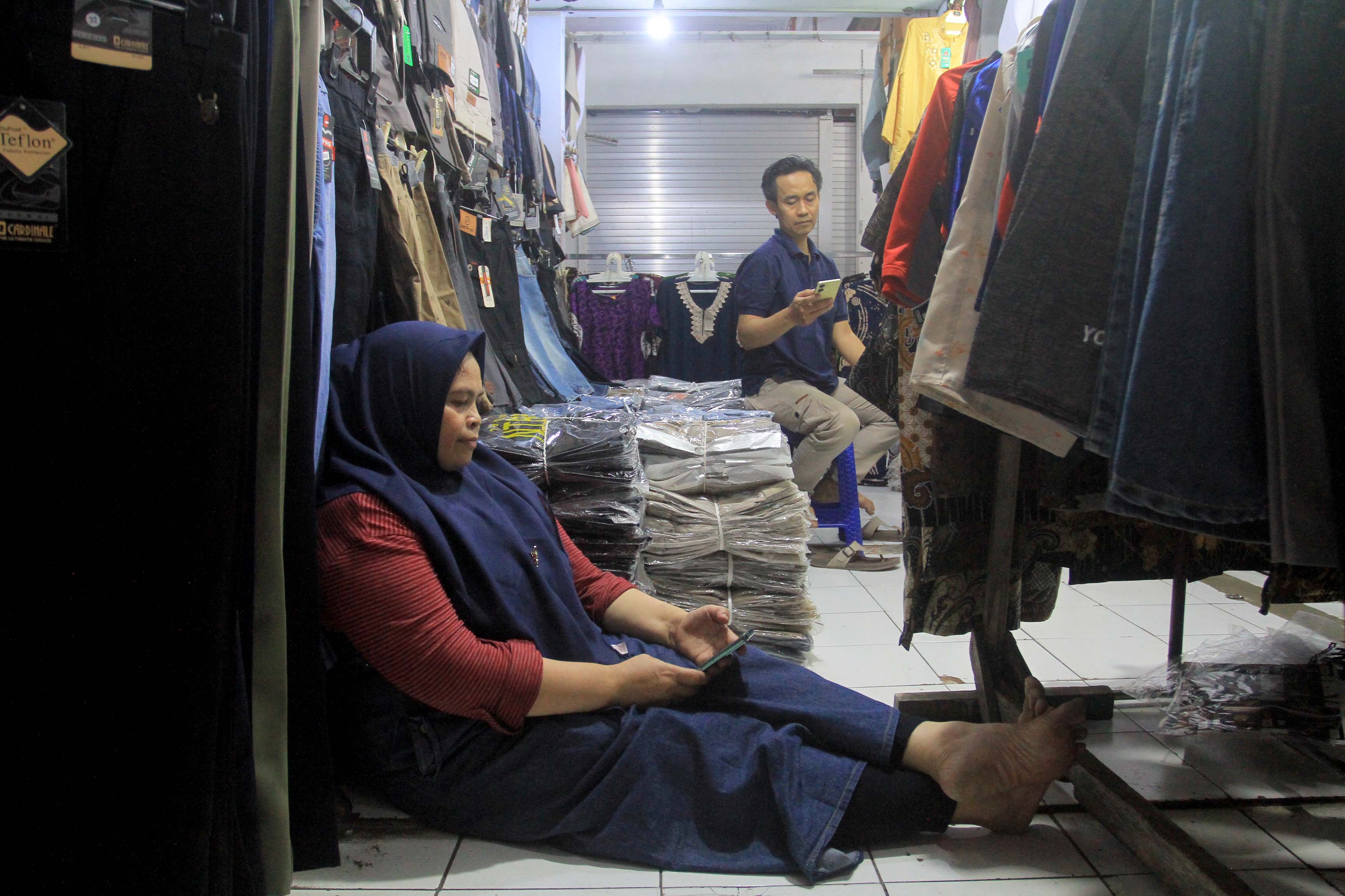 SEPI: Pedagang konveksi di lantai dua Pasar Besar Madiun semakin ditinggalkan pembeli seiring kalah bersaing dengan bisnis online.&nbsp;(BAGAS BIMANTARA/RADAR MADIUN)