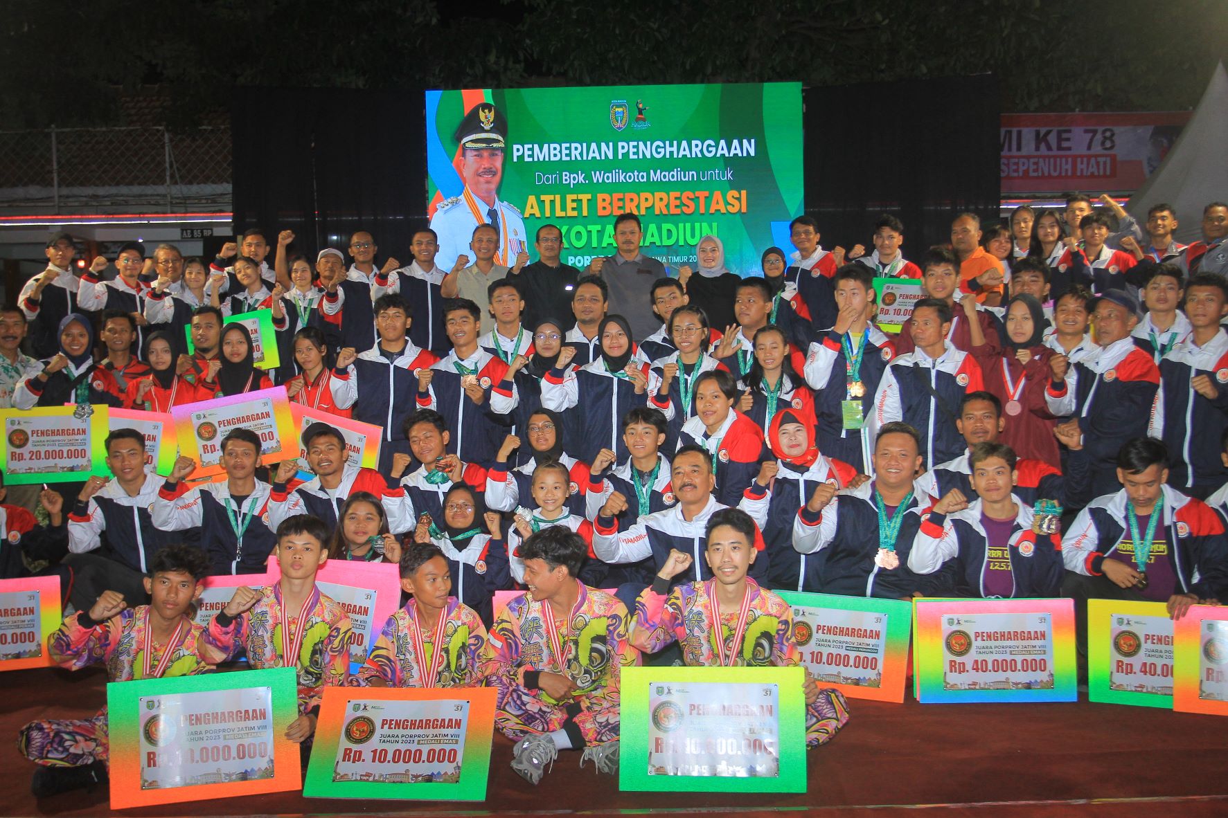 BERPRESTASI: Para atlet peraih medali Porprov Jatim 2023 berswafoto dengan wali kota Maidi di halaman depan balai kota pada Sabtu (23/9) malam lalu. (BAGAS BIMANTARA/RADAR MADIUN)