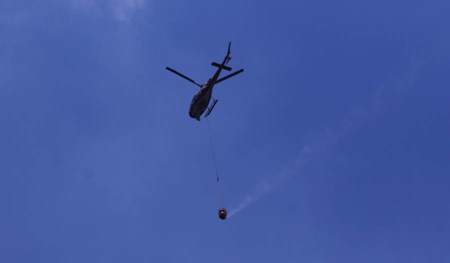 PEMADAMAN JALUR UDARA: Helikopter melakukan water bombing ke Gunung Lawu yang membara kemarin (4/10). Sasarannya Petak 42 RPH Campurejo, Desa Karanggupito, Kendal, Ngawi. (R BAGUS RAHADI/JAWA POS RADA