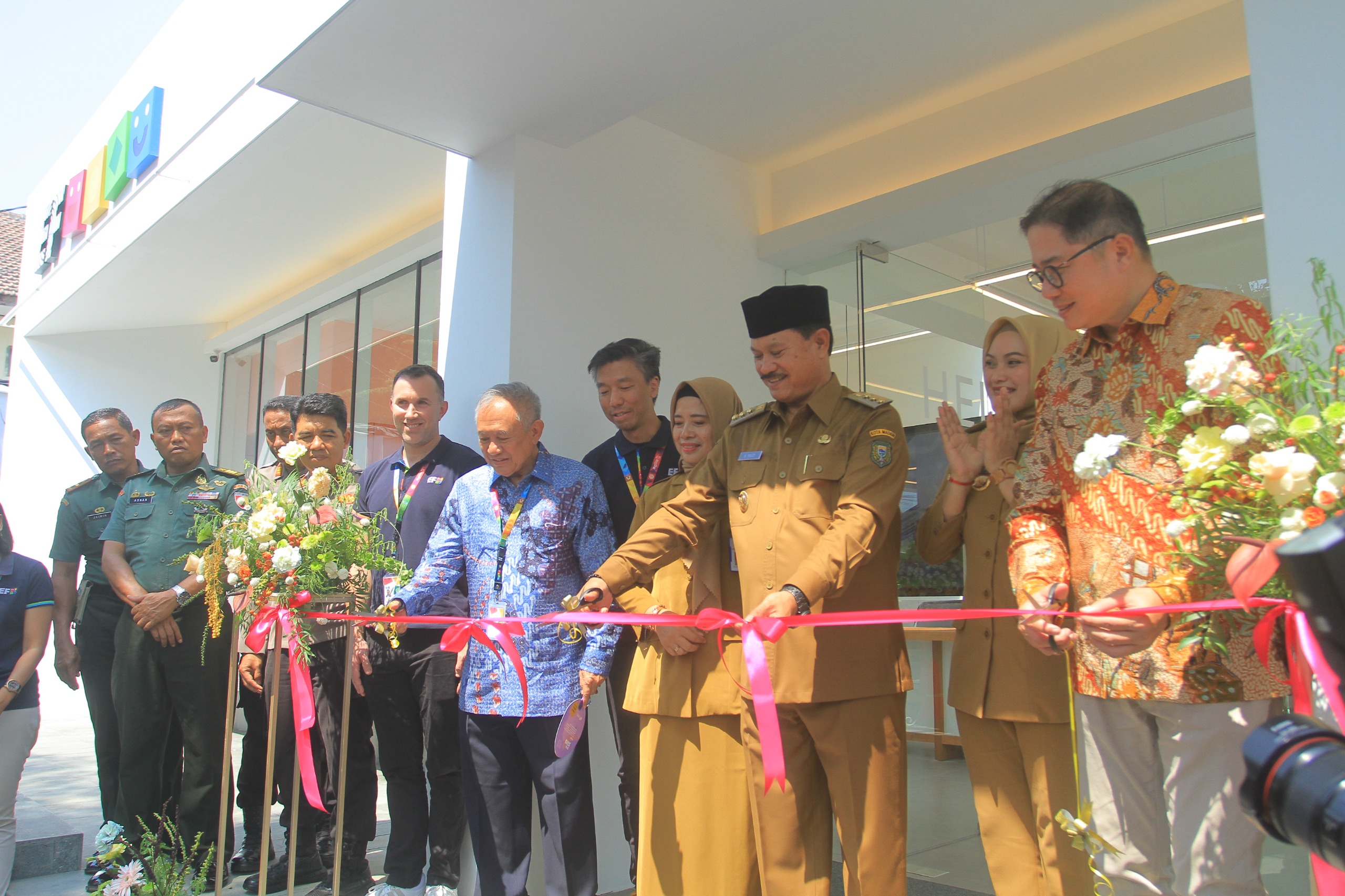 PEMBUKAAN: Wali Kota Madiun Maidi bersama perwakilan EF Kids and Teens Indonesia Afan memotong pita peresmian dalam acara Grand Opening EF Madiun, Selasa (10/10). BAGAS BIMANTARA/JAWA POS RADAR MADIU