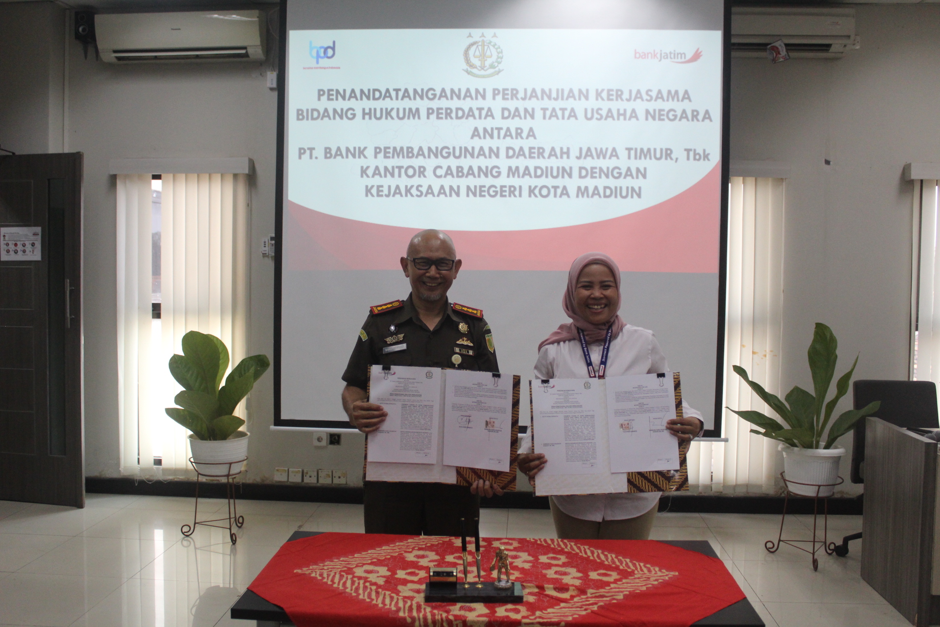 SINERGI: Pinca Bank Jatim Madiun Yetty Fitria Suprapto dan Kajari Kota Madiun Bambang Panca Wahyudi Hariadi saat menandatangani MoU. (TITIS OSI KURNIAWAN/RADAR MADIUN)