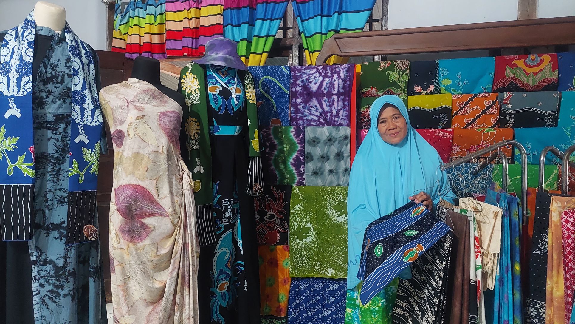 TELATEN: Sri Lestari dan batik hasil buatan kelompok binaannya yang ada di Desa Sidomulyo, Sawahan.&nbsp;(DIAN RAHAYU/RADAR CARUBAN)