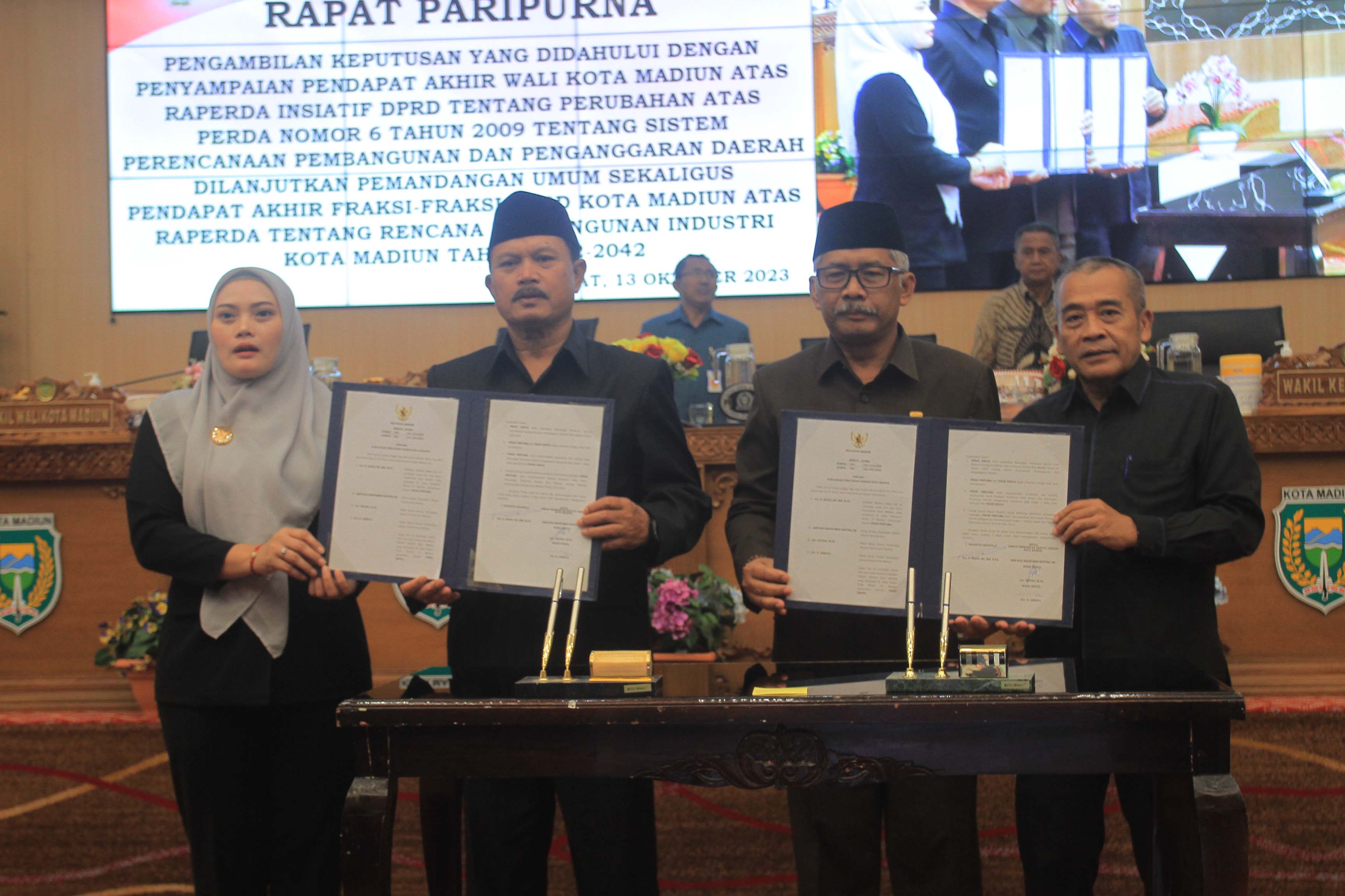 SEPAKAT: Pimpinan DPRD Kota Madiun bersama Wali Kota Madiun Maidi menyetujui dua raperda usulan eksekutif dan inisiatif dewan dalam rapat paripurna, Jumat (13/10). (BAGAS BIMANTARA/RADAR MADIUN)