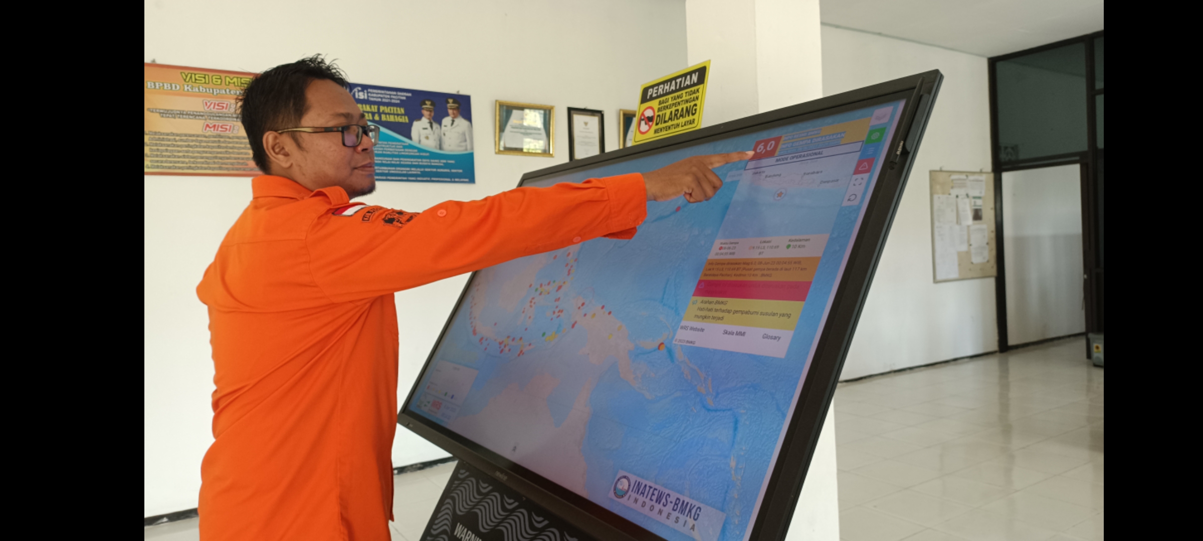 RELATIF KECIL: Petugas BPBD Pacitan menunjukkan pusat gempa yang terlihat di layar monitor WRS-InaTEWS. (NUR CAHYONO/RADAR PACITAN)