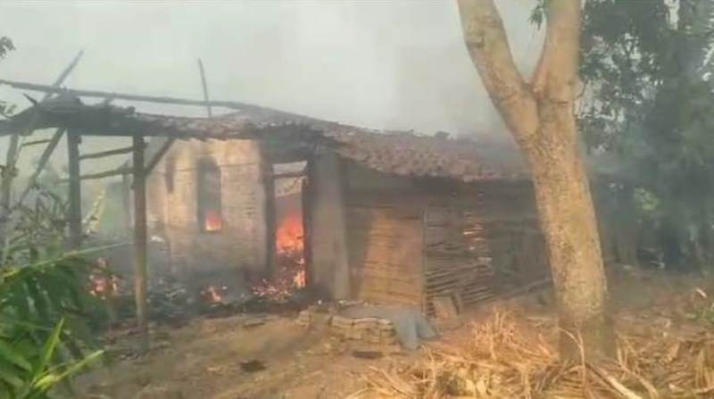 MEMBARA: Petugas Damkar Ponorogo melakukan pemadaman di rumah milik Samino yang terbakar Selasa sore (17/10), anaknya yang ODGJ tewas terbakar.