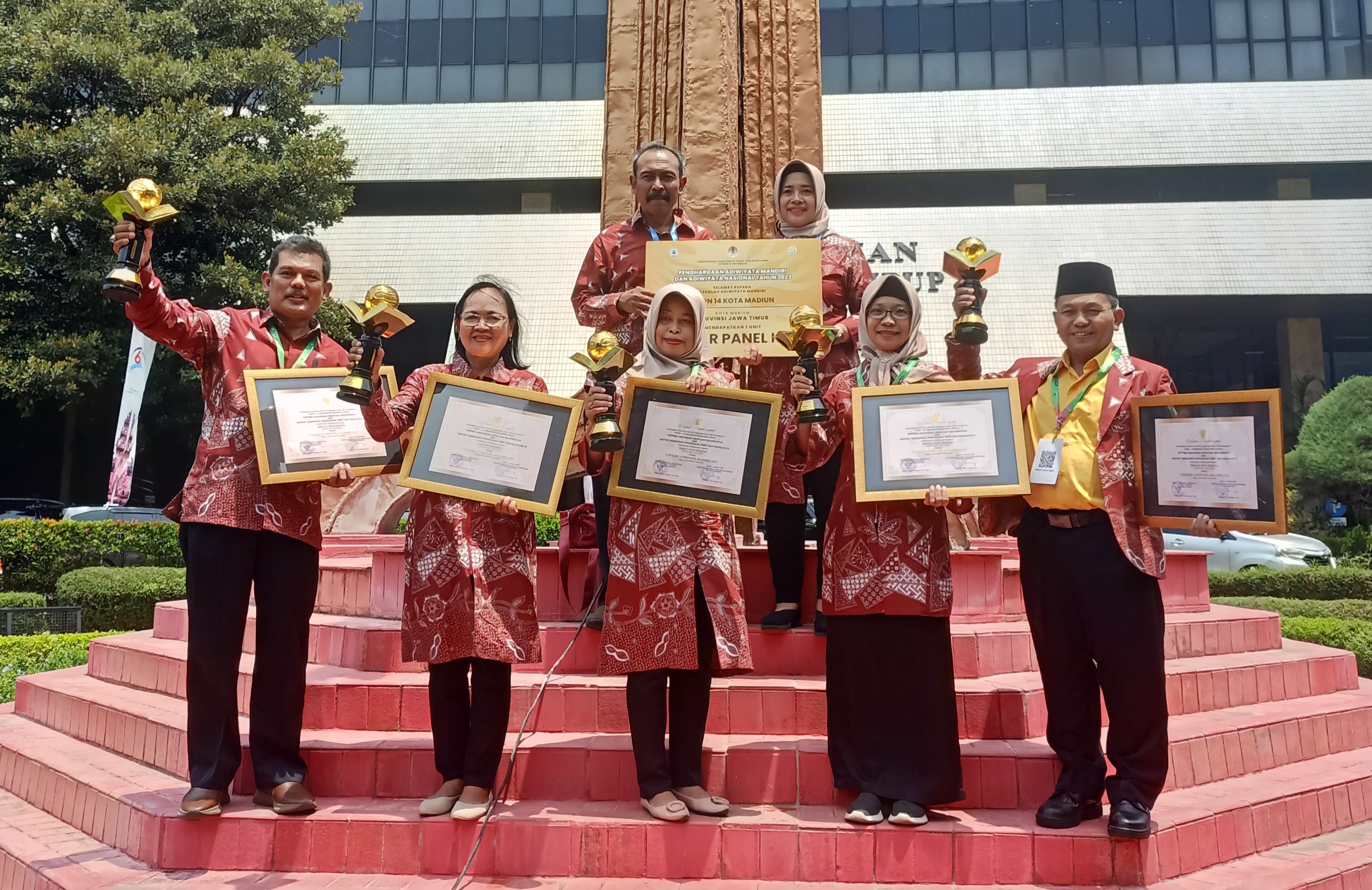 PEDULI LINGKUNGAN: Kadindik Lismawati, Kepala DLH Kota Madiun Aang Marhaendra Budiono bersama sejumlah kepala sekolah berhasil memboyong 12 penghargaan Adiwiyata. (DLH UNTUK RADAR MADIUN)