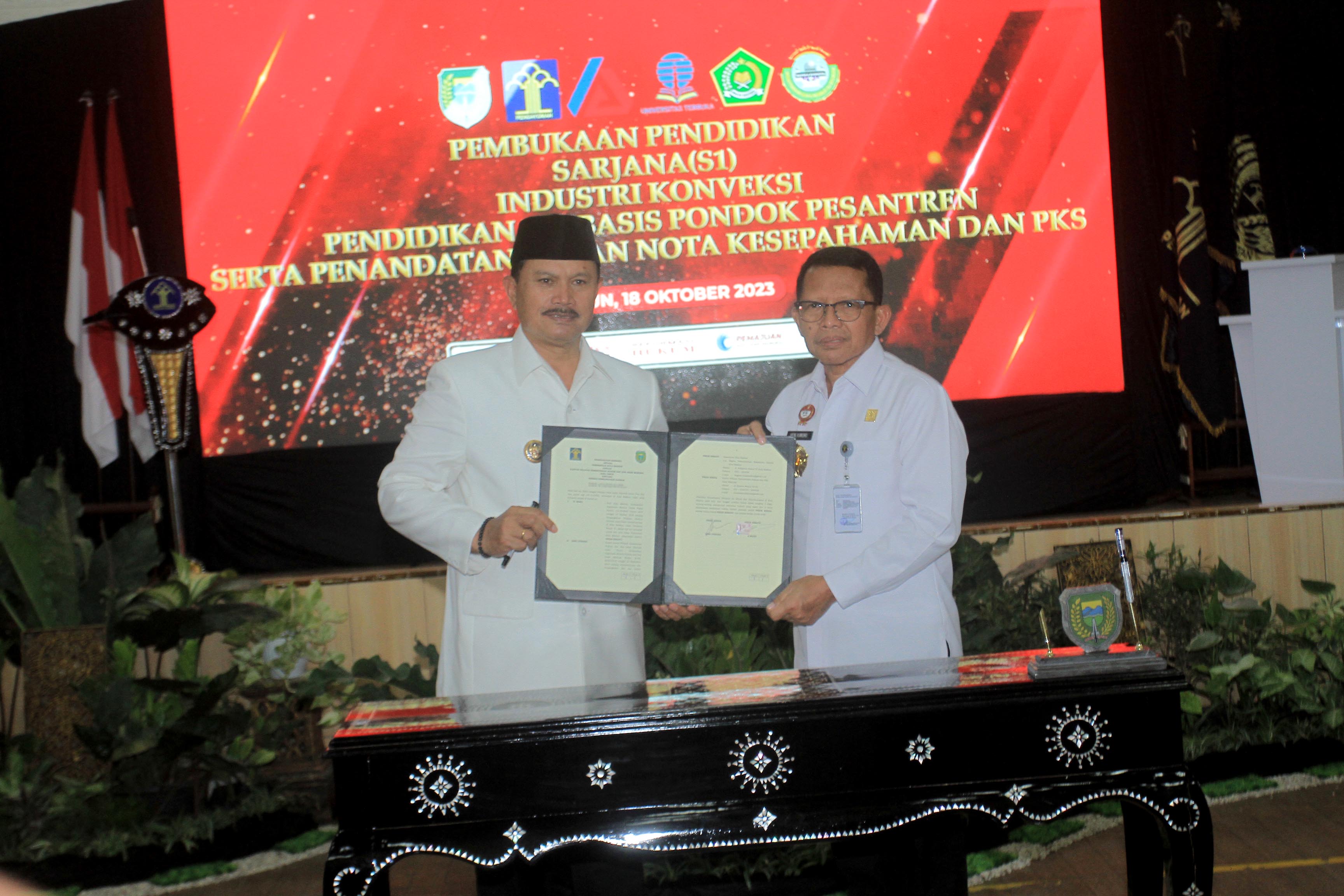 BEASISWA KULIAH: Wali Kota Madiun Maidi saat memakaikan jas almamater kepada narapidana Lapas Kelas I Madiun kemarin (18/10). (BAGAS BIMANTARA/RADAR MADIUN)