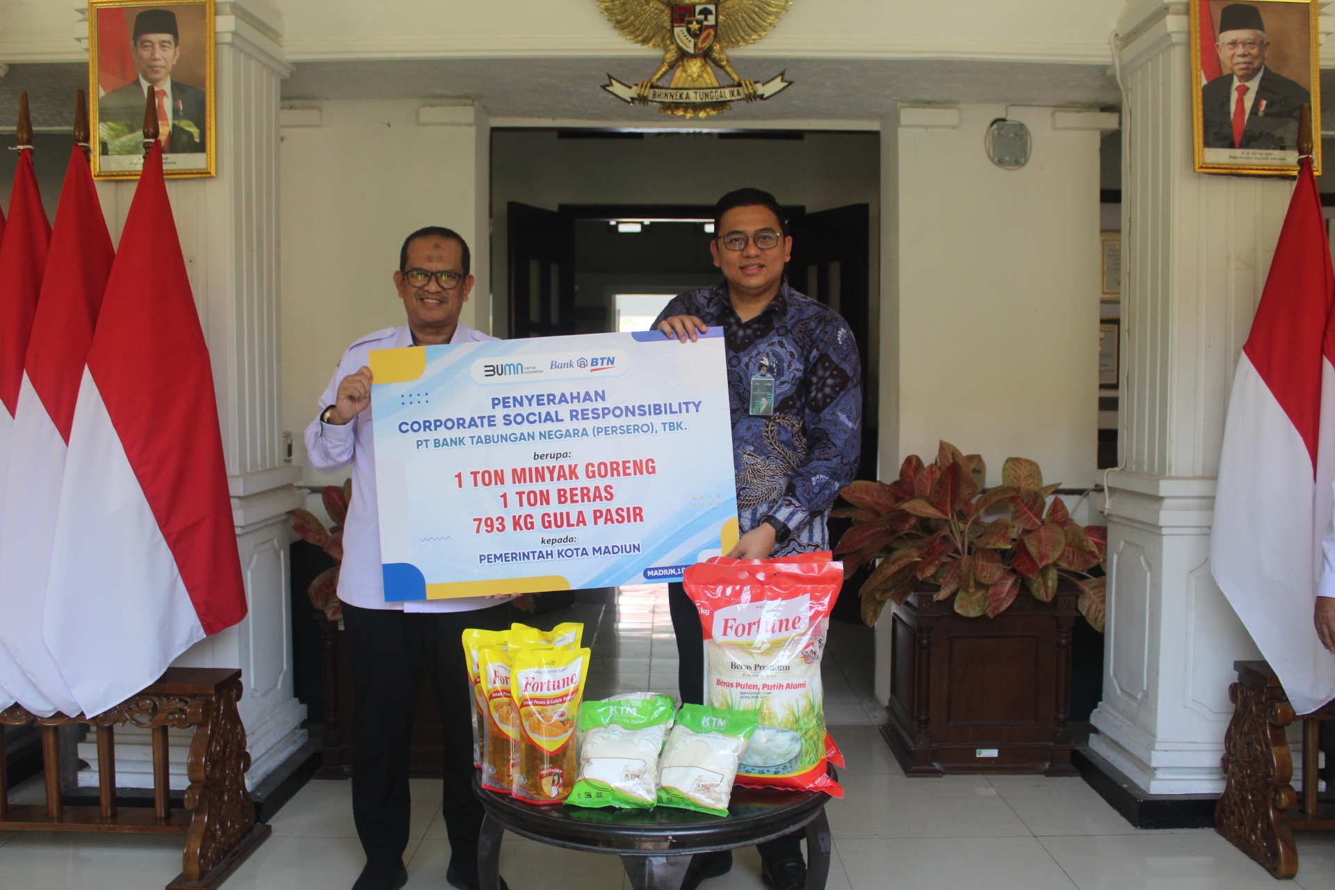 SIMBOLIS: Branch Manager BTN KC Madiun Adrian PH Marbun menyerahkan bantuan sembako kepada pemkot melalui Sekda Kota Madiun Soeko Dwi Handiarto. (ARCHI FIRDAUS/RADAR MADIUN)