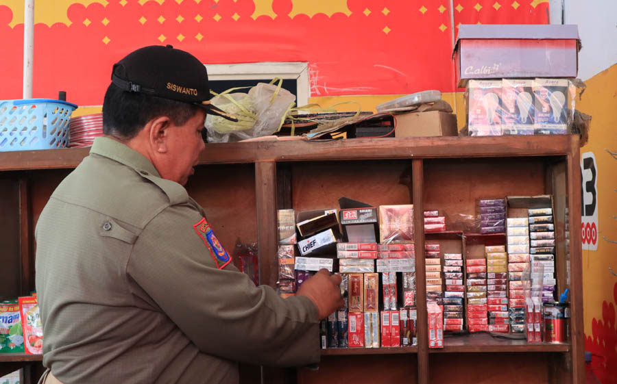 OPERASI: Petugas Satpol PP dan Damkar bersama Bea Cukai Madiun melakukan operasi gempur rokok ilegal di sejumlah toko di Kecamatan Jenangan kemarin (1/11). (SUGENG DWI N./JAWA POS RADAR PONOROGO)