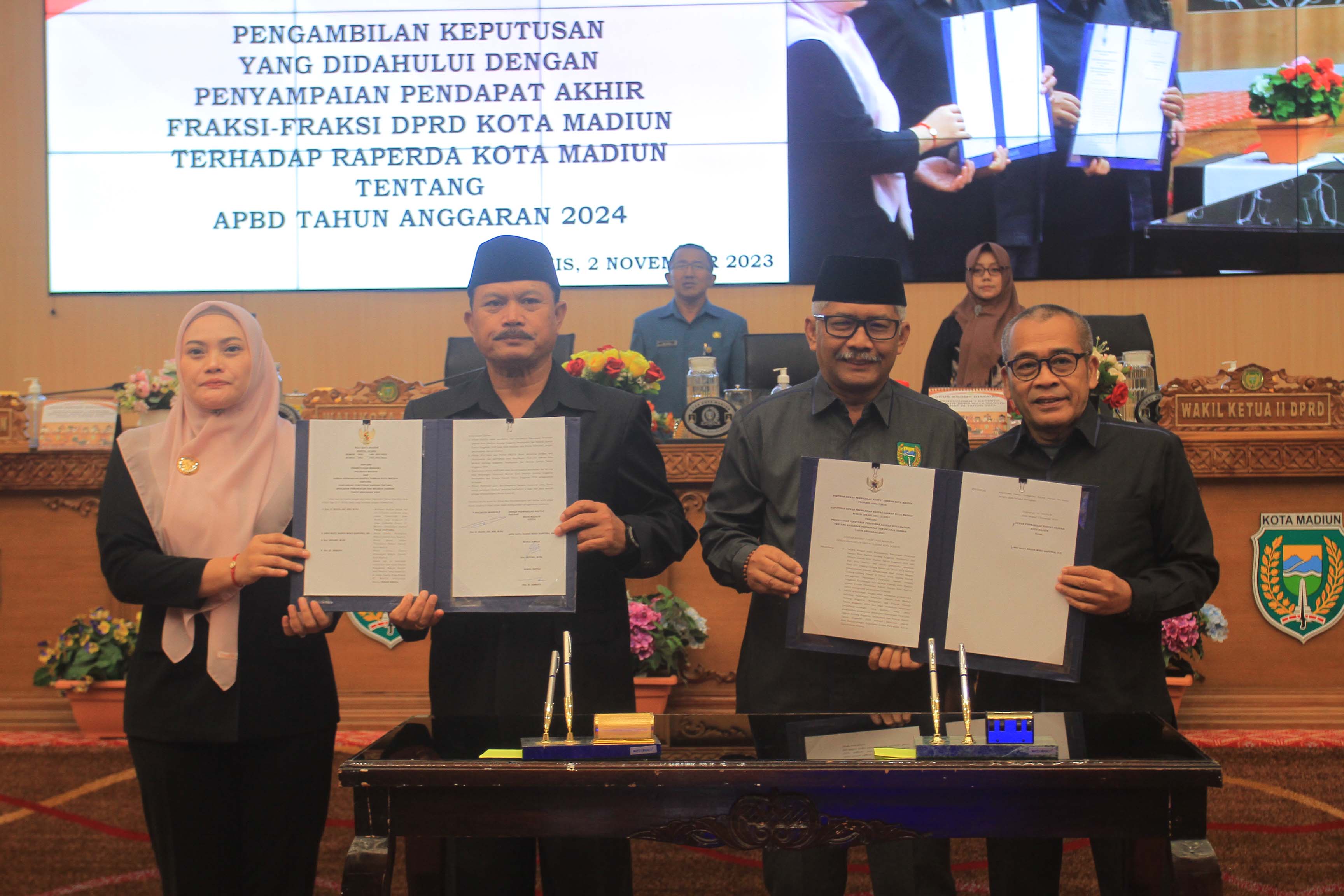 SAH: Pimpinan DPRD Istono dan Armaya bersama Wali Kota Maidi beserta Wawali Inda Raya meneken nota kesepahaman penetapan raperda APBD 2024 menjadi perda, Kamis (2/11). (BAGAS BIMANTARA/RADAR MADIUN)