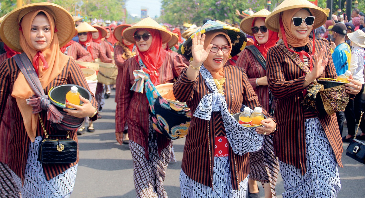 BUDAYA: Ketua TP PKK Kota Madiun Yuni Setyawati (dua dari kanan) ikut kirab jamu gendong di Jalan Pahlawan, Sabtu (4/11) lalu.&nbsp;(BAGAS BIMANTARA/RADAR MADIUN)