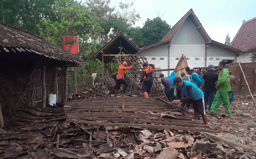 RATA TANAH: Warga dan petugas gabungan kerja bakti membersihkan puing bangunan warga Desa Mangunharjo, Ngawi, yang ambruk disapu angin kencang. (ASEP SYAEFUL BACHRI/JAWA POS RADAR NGAWI)