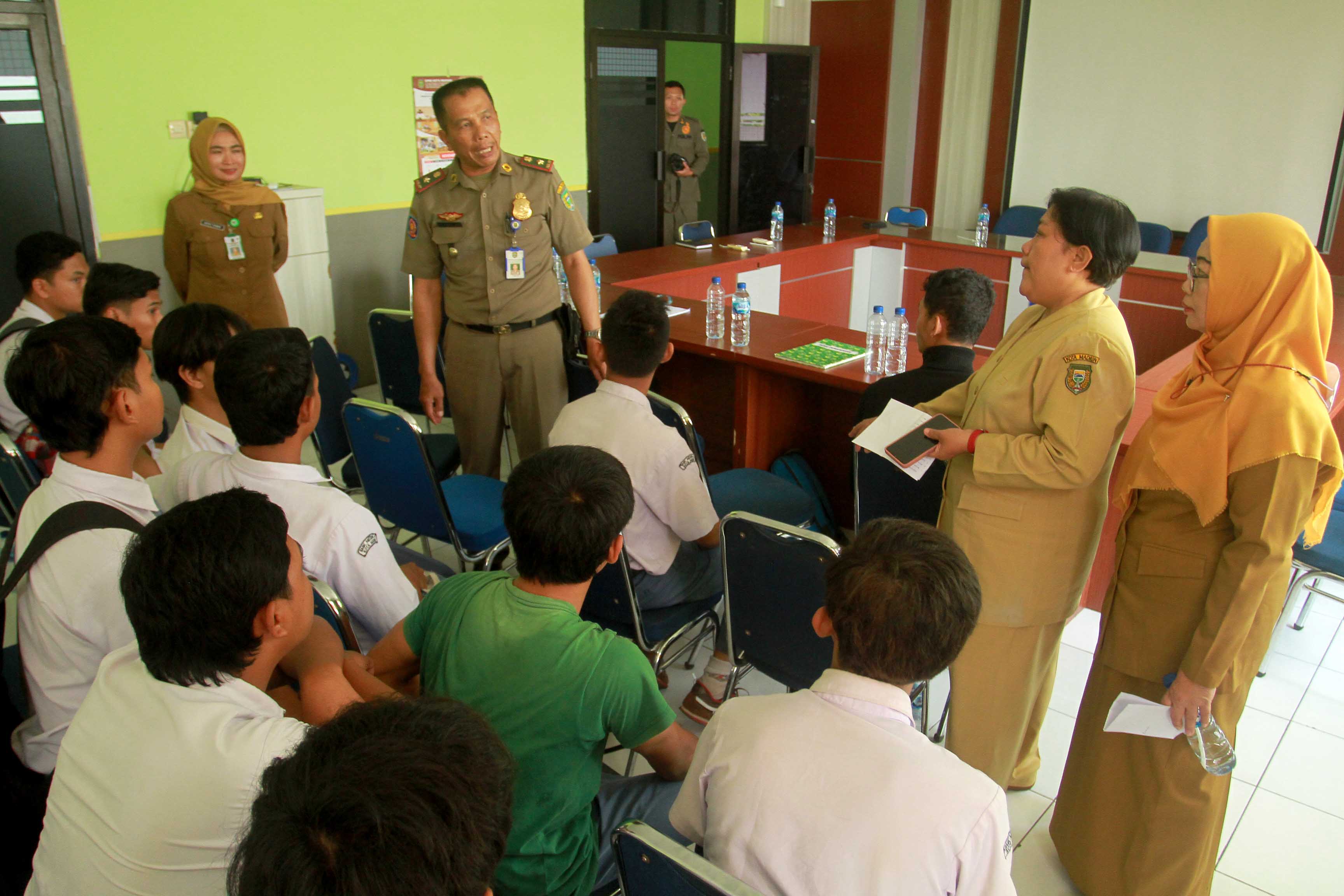 DIBINA: Puluhan pelajar SMA/SMK diamankan petugas Satpol PP dan Damkar Kota Madiun saat kedapatan bolos sekolah di warkop, Senin (6/11). (BAGAS BIMANTARA/RADAR MADIUN)