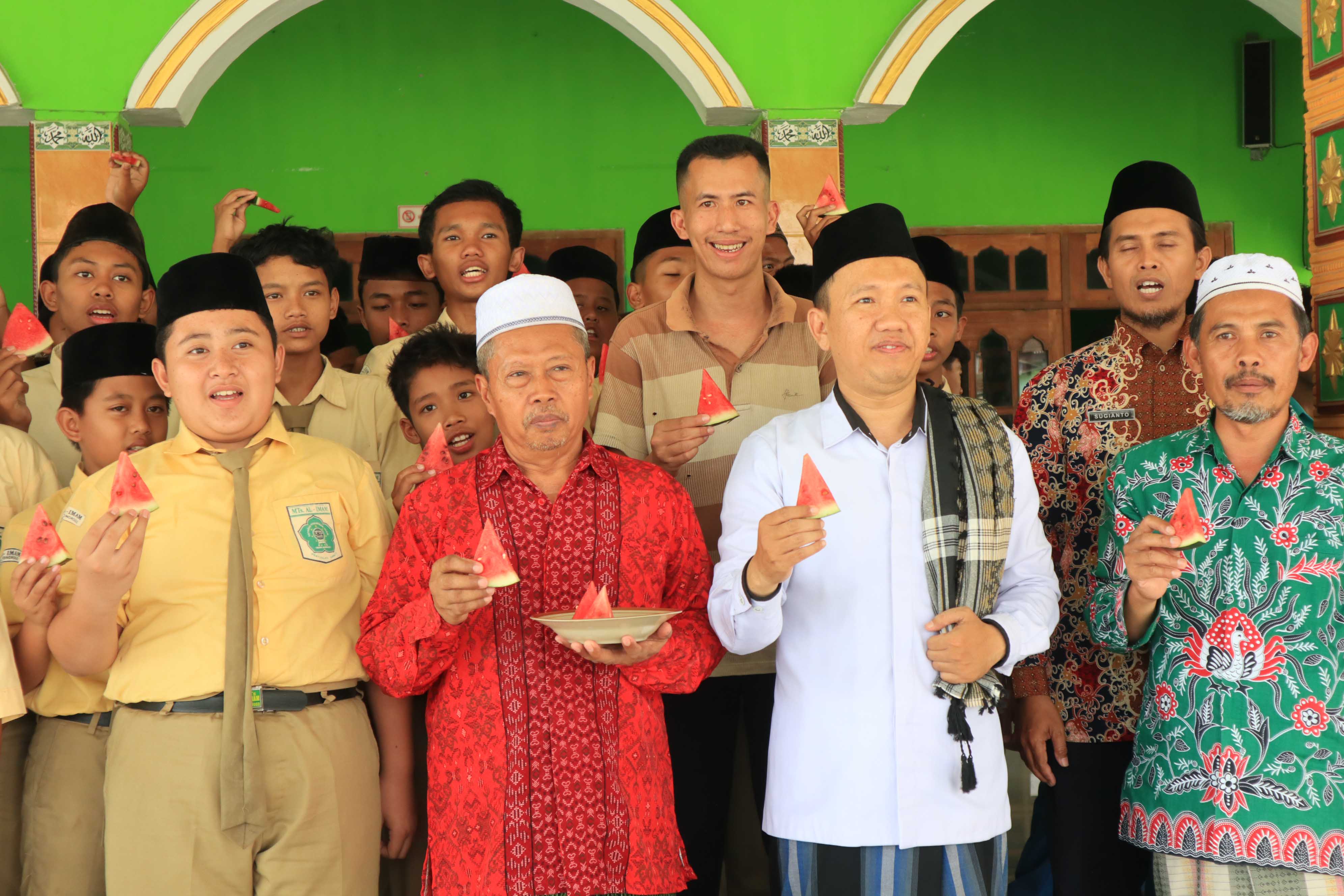 SOLIDARITAS: Pelajar, pengurus KUA Sawoo, dan warga mengangkat buah semangka yang menjadi simbol dukungan terhadap Palestina usai salat gaib dan doa bersama, kemarin (8/11).&nbsp;(SUGENG DWI N./JAWA POS RA