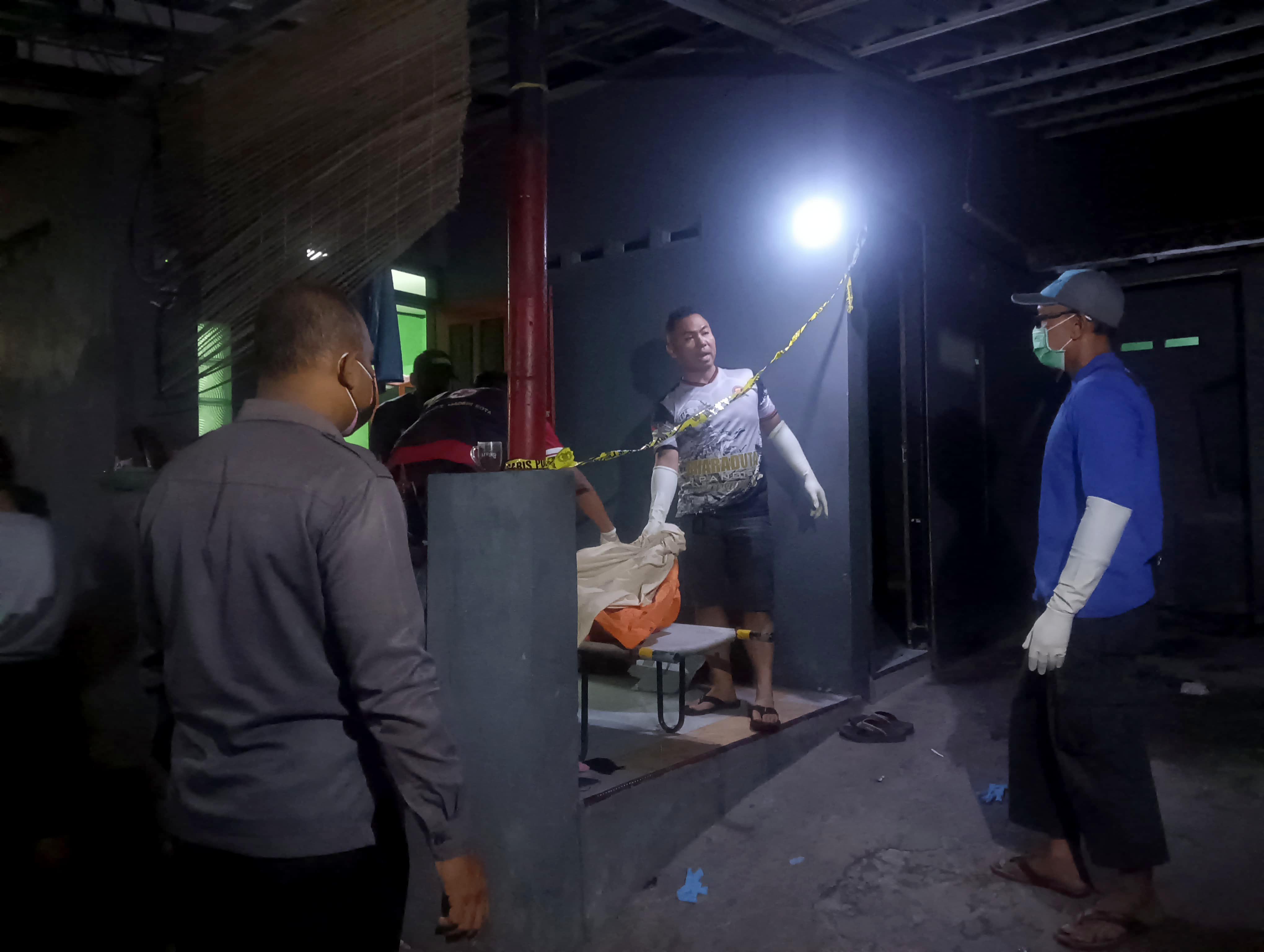TAK BERNYAWA: Polisi mengevakuasi jasad Tjoa Kong Ing dari dalam kamar kosnya pada Rabu (15/11) malam. (ERLITA HERMININGSIH/RADAR MADIUN)
