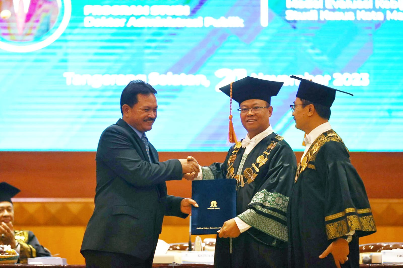 STRATA-3: Wali Kota Madiin Maidi saat mengikuti sidang terbuka gelar doktor administrasi publik di Gedung Universitas Terbuka (UT) Convention Center kemarin (21/11). (WS HENDRO DISKOMINFO)