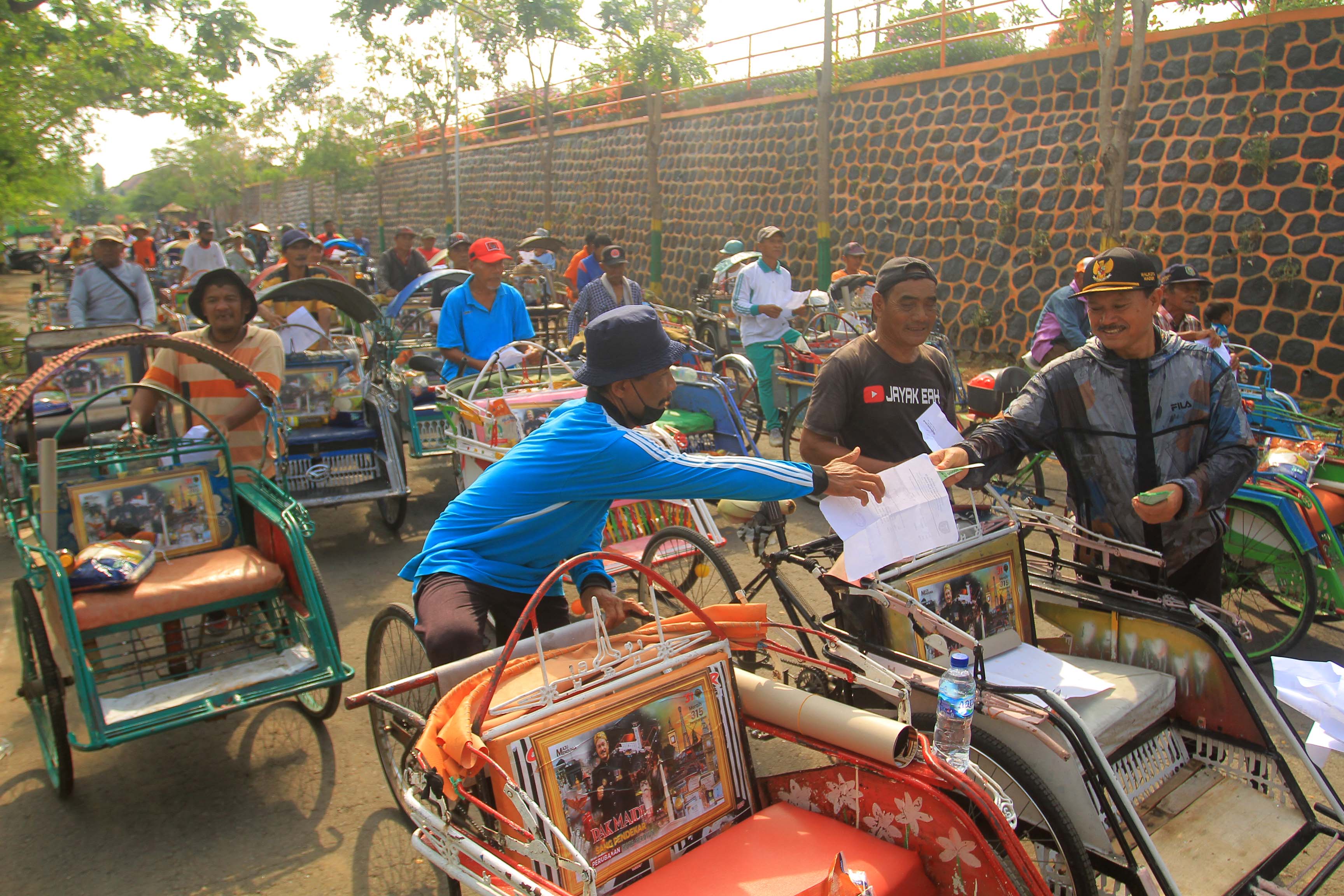 MISI SOSIAL: Wali Kota Madiun Maidi saat membahikan paket sembako kepada ratusan tukang becak di Taman Lalu Lintas Bantaran Madiun kemarin (24/11). (BAGAS BIMANTARA/RADAR MADIUN)