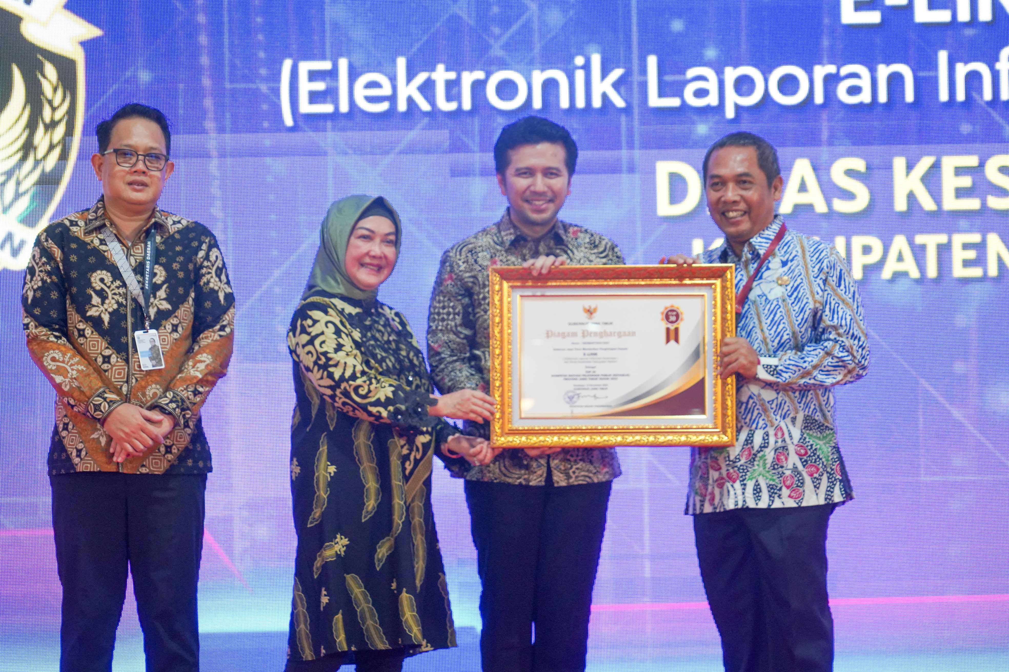 INOVATIF: Wagub Jatim Emil Dardak dan Deputi Bidang Pelayanan Publik Kemenpan RB Diah Natalisa menyerahkan penghargaan kepada Pj Bupati Madiun Tontro Pahlawanto. (DISKOMINFO KOTA MADIUN)