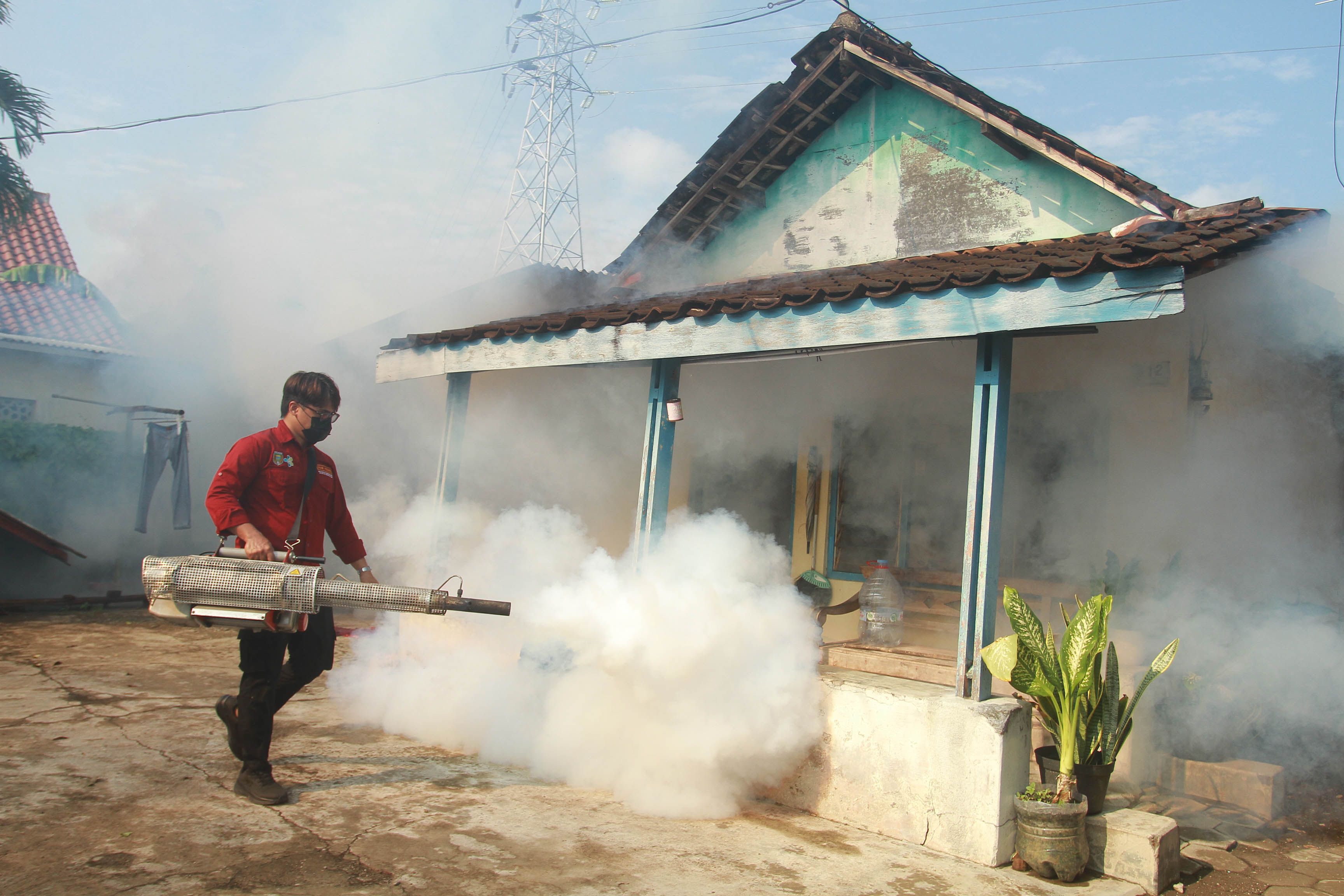 PENGASAPAN: Petugas dari Dinkes-PPKB Kota Madiun melakukan fogging di Kelurahan Winongo, Manguharjo kemarin (29/11).&nbsp;(BAGAS BIMANTARA/RADAR MADIUN)
