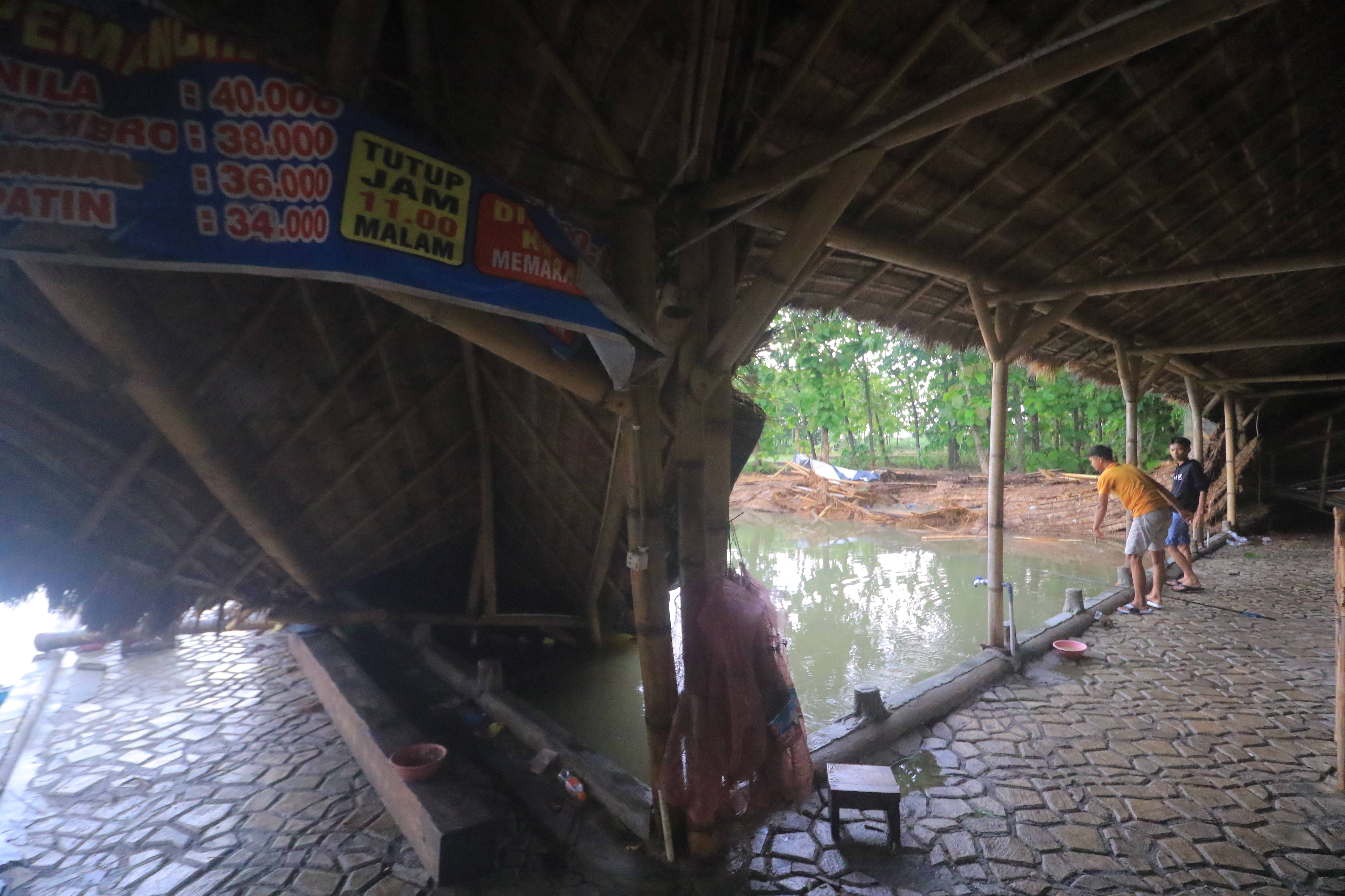 AMBRUK: Atap di kolam pemancingan Banyumili, Desa Mojopurno ambruk diterjang angin puting beliung, kemarin (3/12). (R. BAGUS RAHADI/RADAR CARUBAN)
