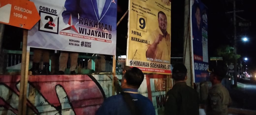 STERILKAN: Petugas satpol PP mencopoti APK di kawasan Ahmad Yani. (NUR CAHYONO/RADAR PACITAN)