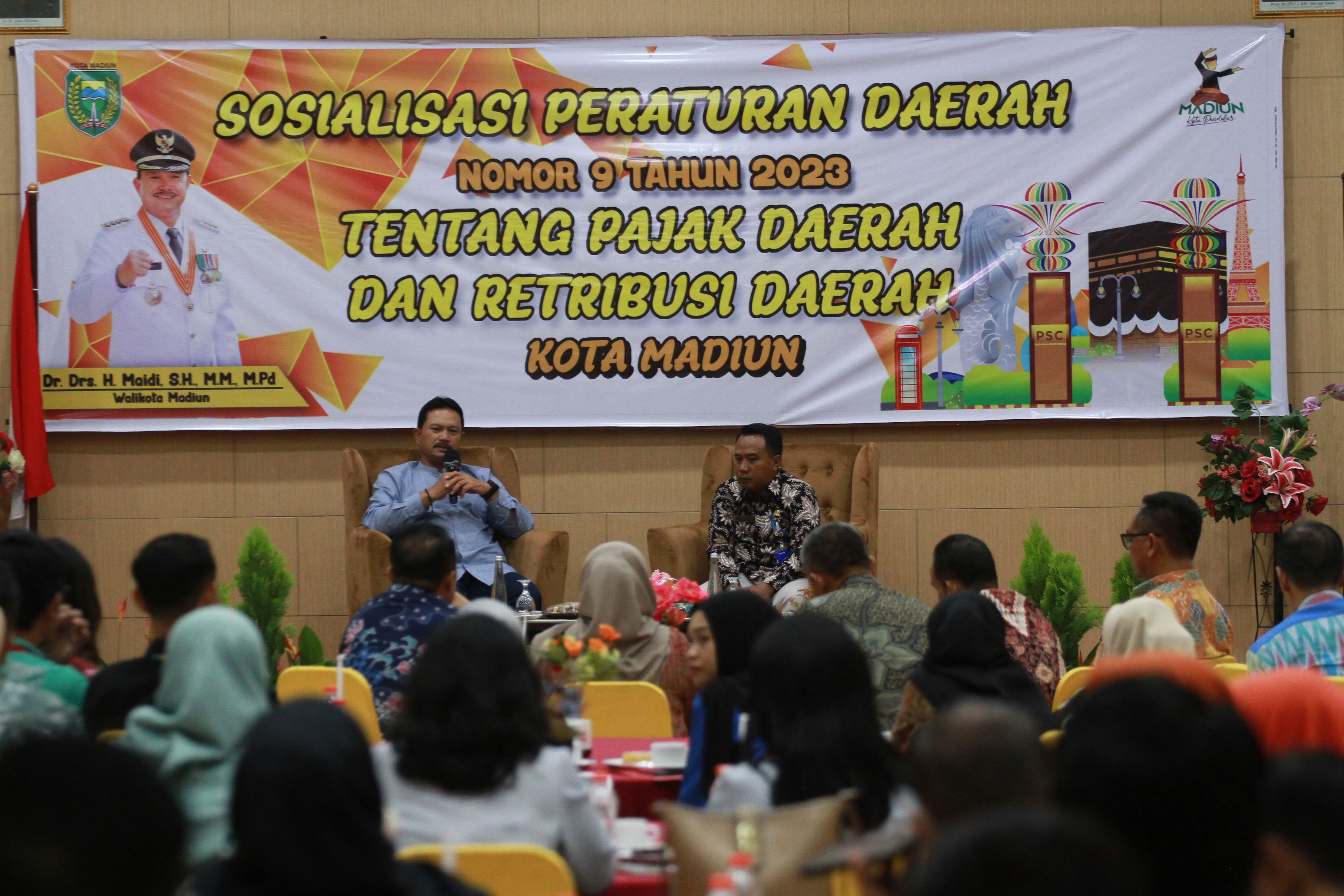 KEJAR TARGET: Wali Kota Maidi bersama Bapenda Kota Madiun mensosialisasikan Perda 9/2023 tentang Pajak dan Retribusi Daerah di RM Ayam Goreng Pemuda kemarin (8/12). (BAGAS BIMANTARA/RADAR MADIUN)