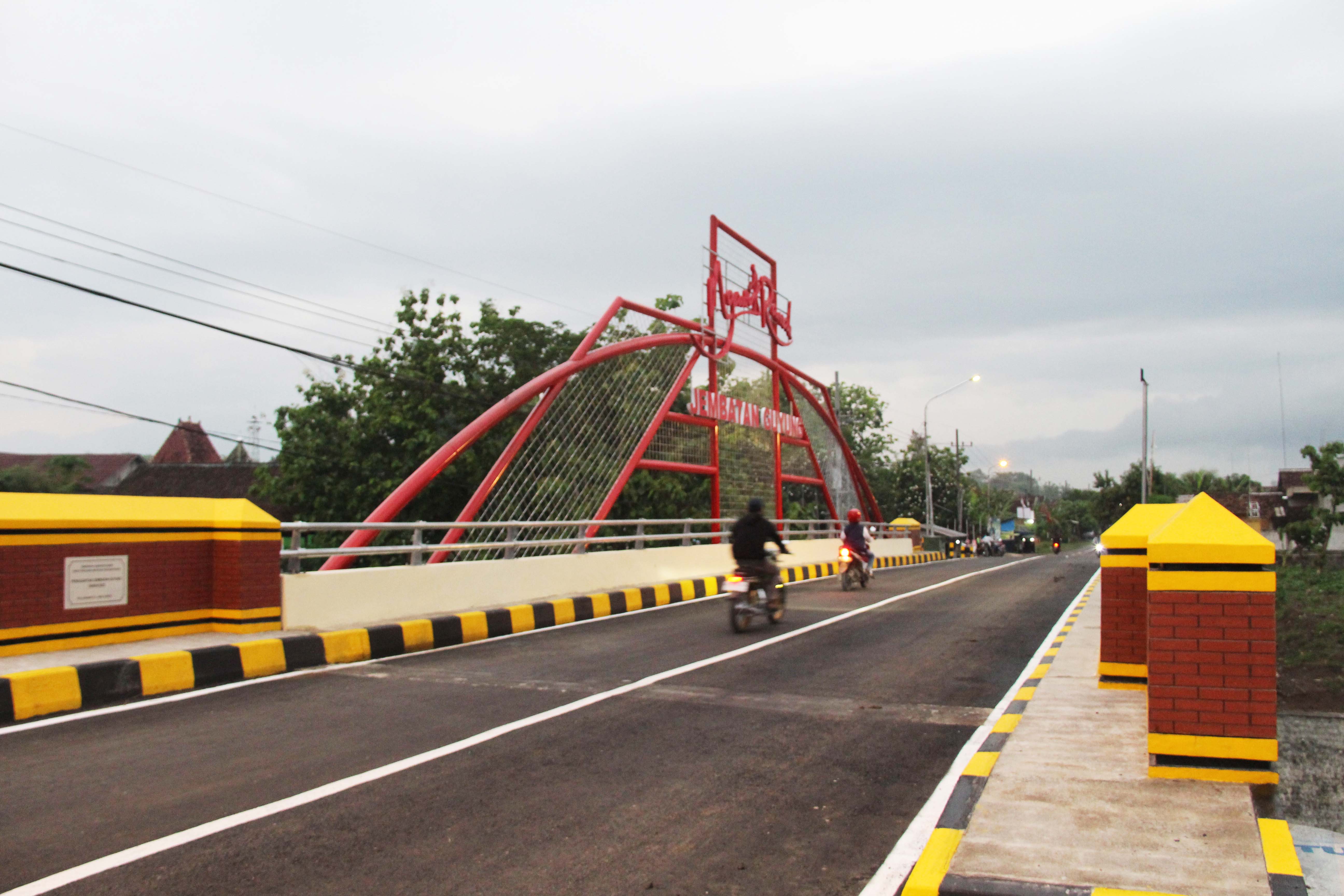 LEBIH LEBAR: Pengendara bermotor melintasi Jembatan Guyung, Gerih, Ngawi, yang sudah selesai dibangun ulang.&nbsp;(ASEP SYAEFUL BACHRI/JAWA POS RADAR NGAWI)