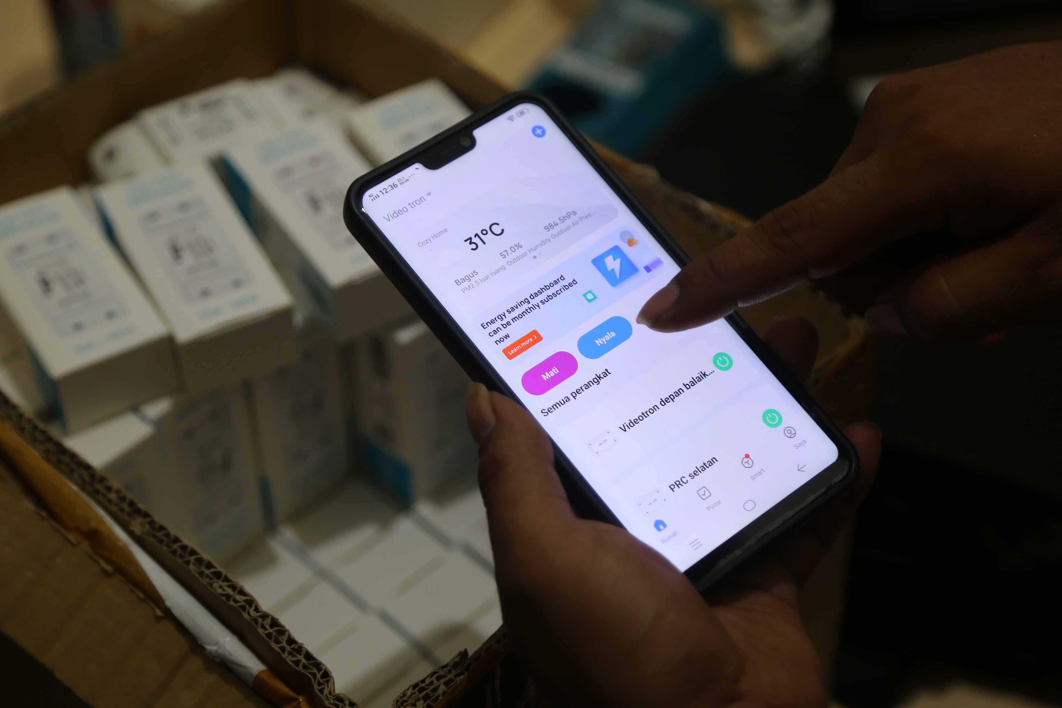 TERKONEKSI INTERNET: Salah seorang petugas Diskominfo Kota Madiun memeriksa peranti on-off braker di panel PJU kawasan Jalan Pahlawan. (BAGAS BIMANTARA/RADAR MADIUN)