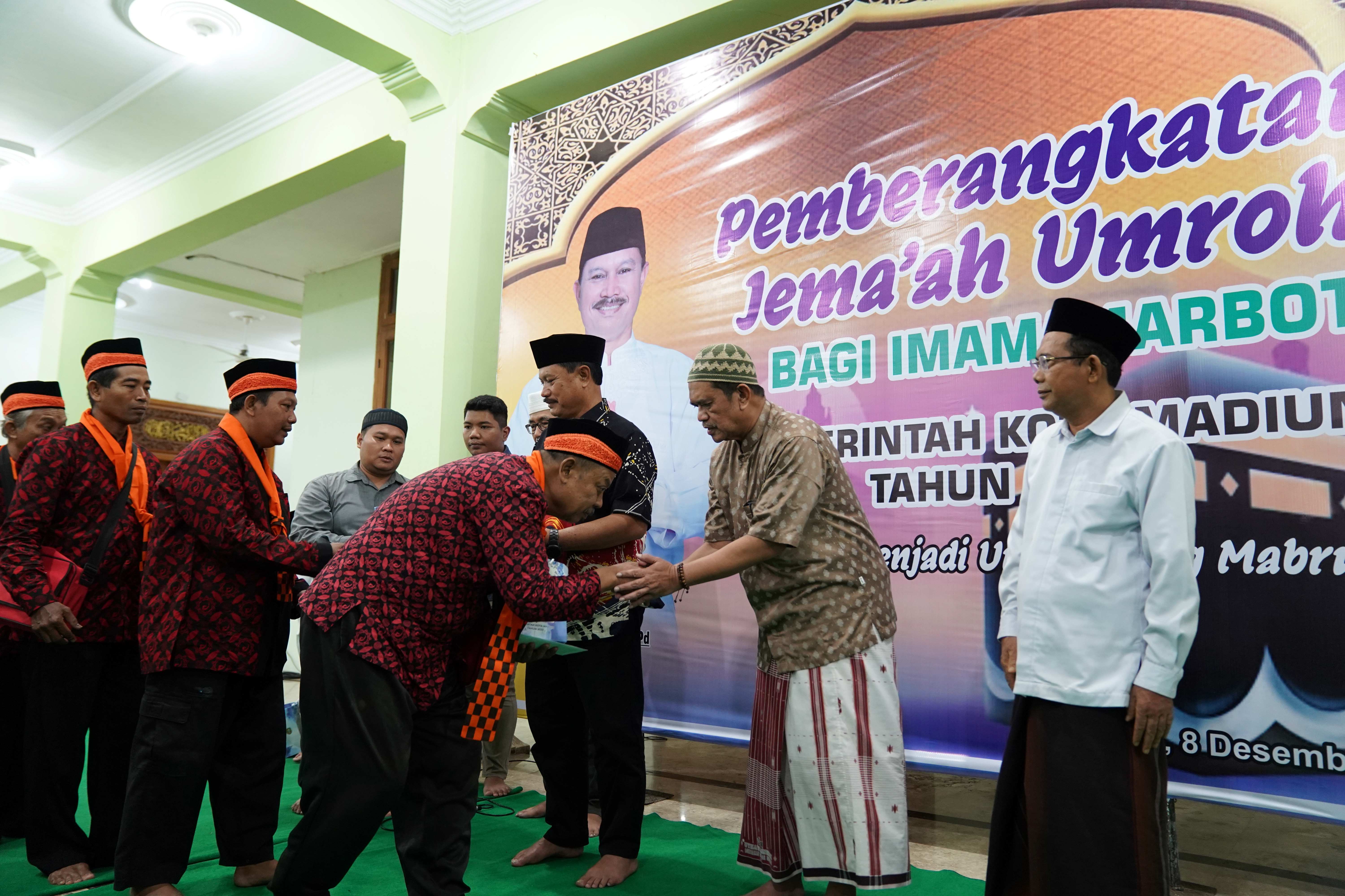 TAMU ALLAH: Wali Kota Maidi secara simbolis melepas dan memberangkatkan 30 marbut-imam masjid menunaikan ibadah umrah gratis dari Masjid Baitul Hakim, Sabtu (9/12) pagi. (DISKOMINFO KOTA MADIUN)