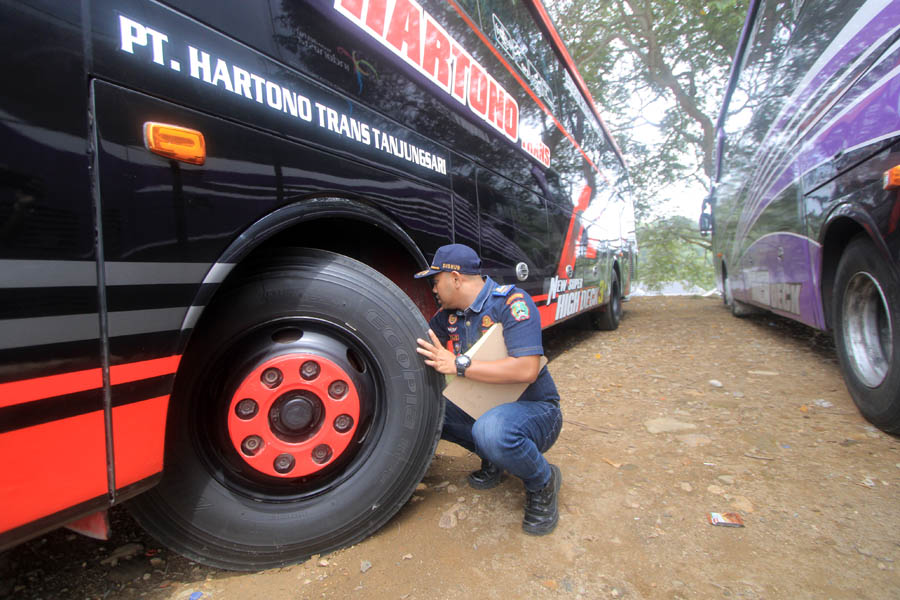 TRANSPORTASI DARAT: Petugas melakukan pemeriksaan terhadap minibus dan bus pariwisata yang terparkir di kawasan Telaga Sarangan kemarin (10/12). (AJI PUTRA/ JAWA POS RADAR MAGETAN)