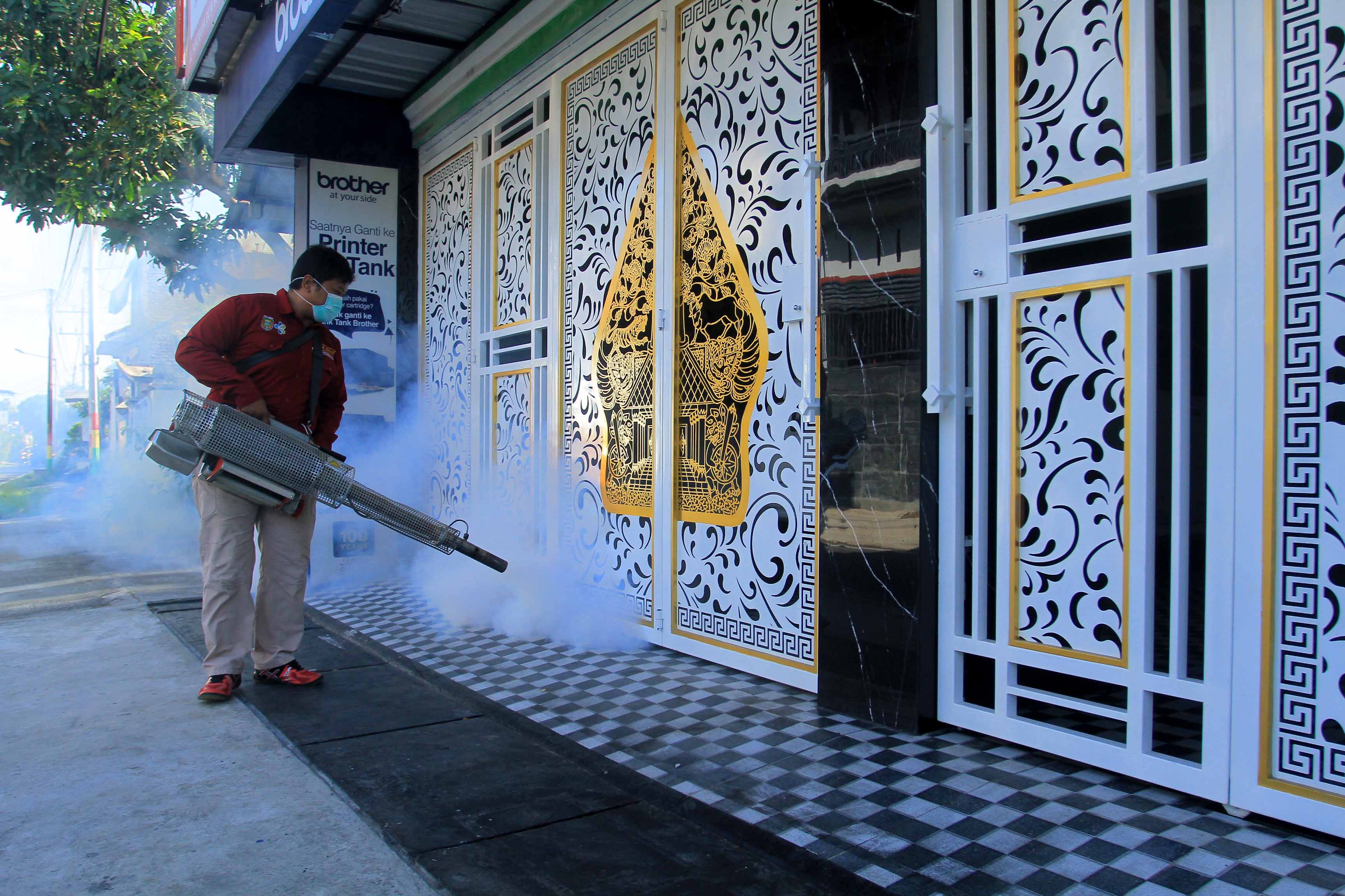 DIASAPI: Petugas dari Dinkes-PPKB Kota Madiun melakukan fogging di lingkungan Perumahan Panorama Wilis setelah seorang warga Demangan positif DBD kemarin (15/12). (BAGAS BIMANTARA/RADAR MADIUN)