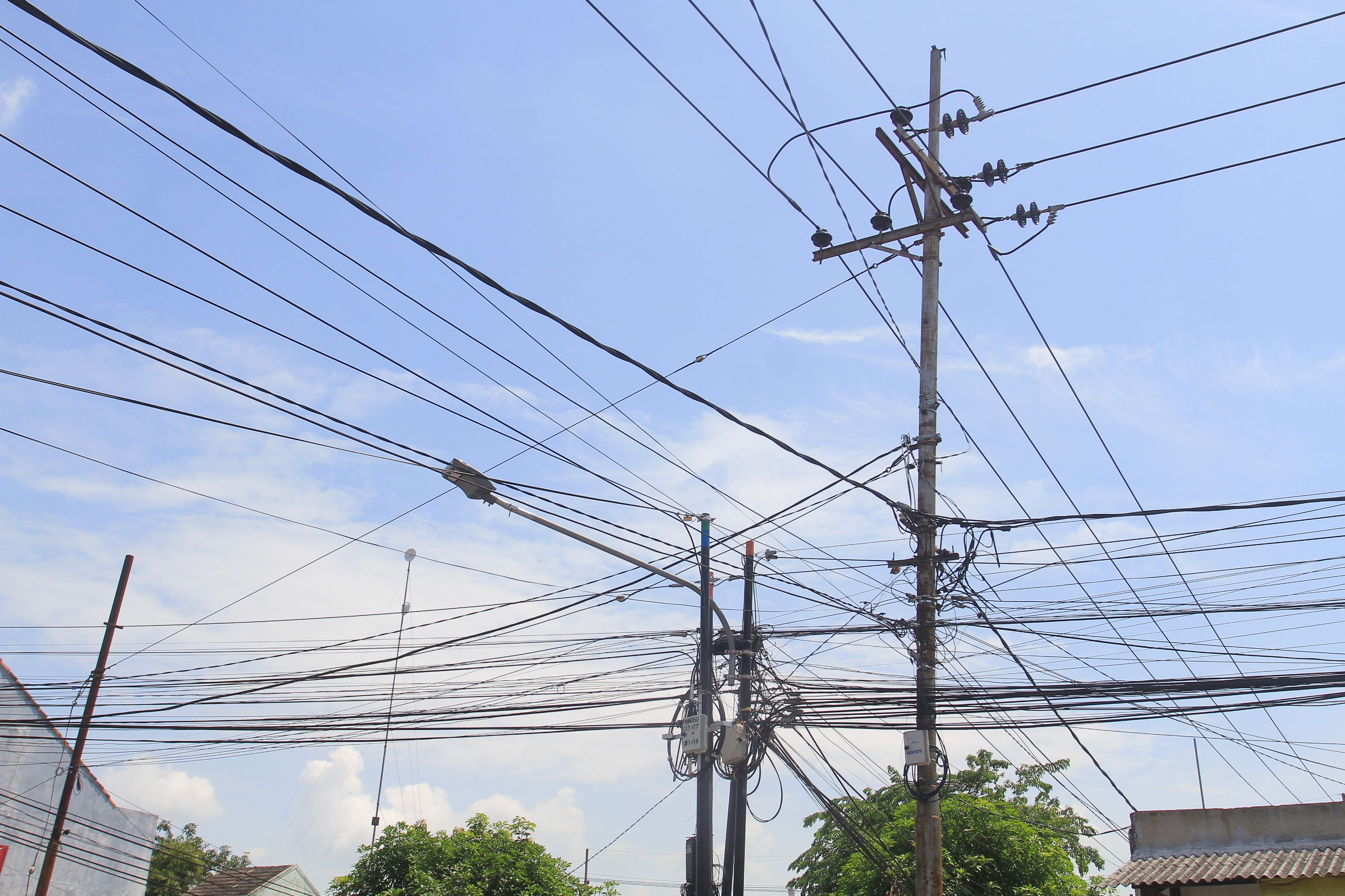 MERUSAK ESTETIKA: Salah satu titik kabel semrawut di Kota Madiun. Pemkot berencana kumpulkan provider terkait masalah tersebut.&nbsp;(BAGAS BIMANTARA/RADAR MADIUN)